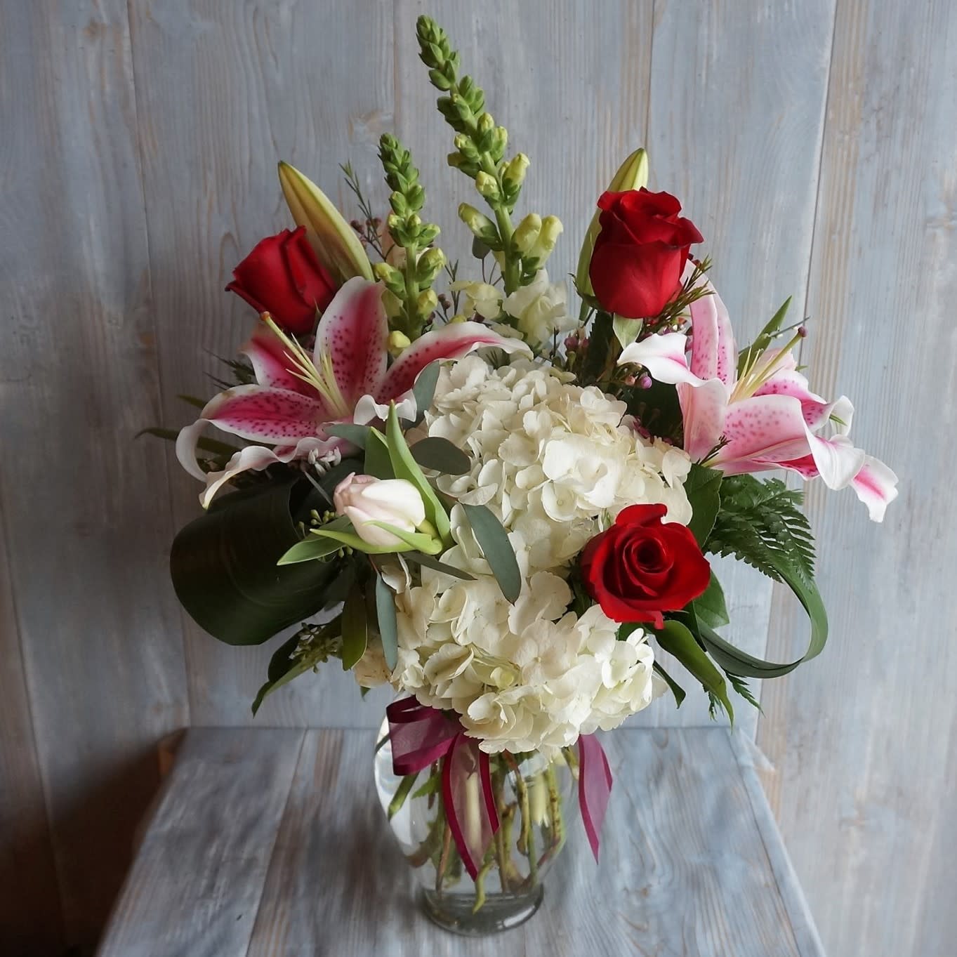 Love is in the Air - Vase arrangement of white hydrangea, snap dragons, Ecuadorian red roses, tulips and stargazer lilies. 