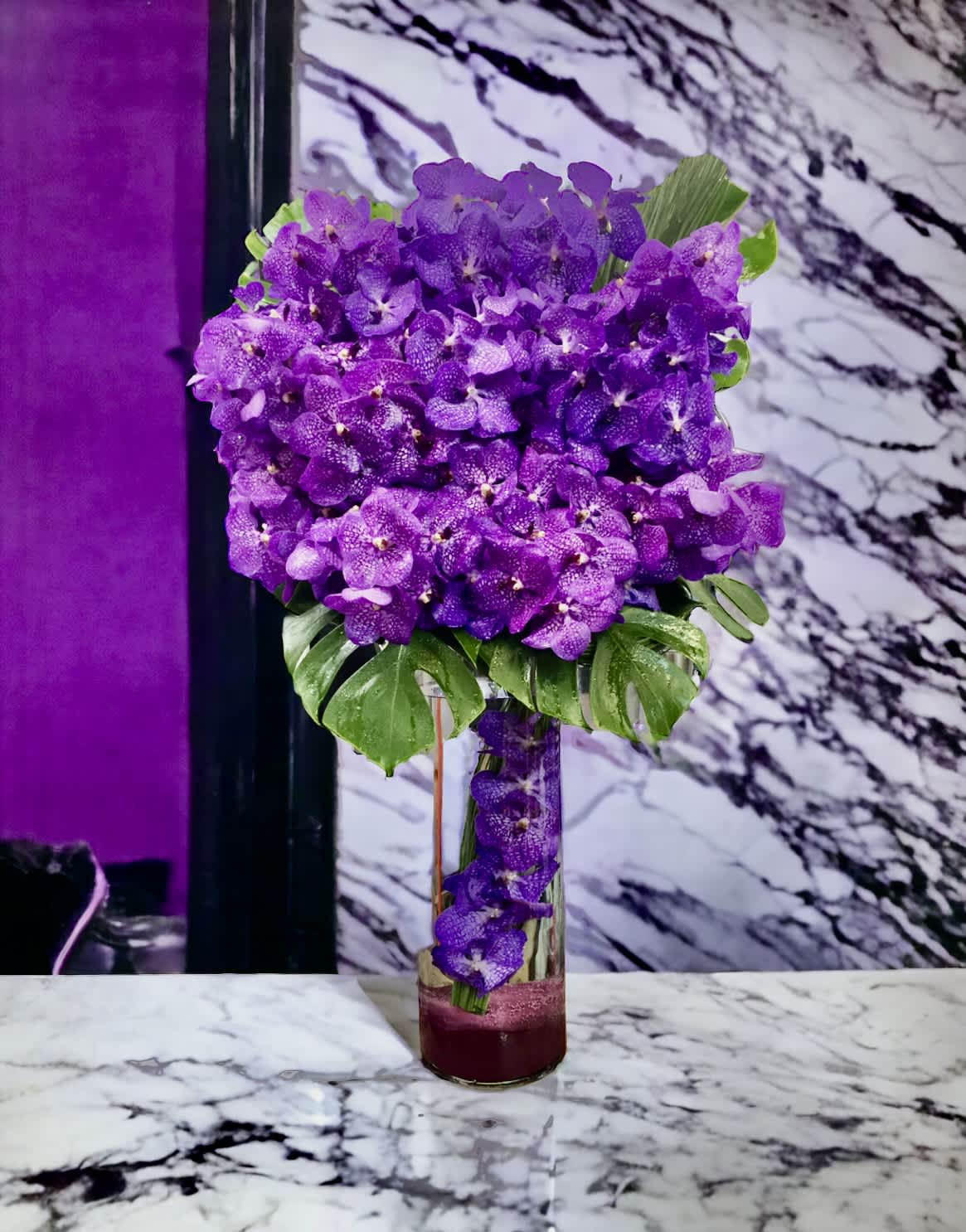 ARMY power - Flower: 35 Vanda orchids with Mostera leaves  Vase : 20” by 8” glass vase.  Vanda bloom at the bottom, with the overall arrangement standing 36” and 20” wide 