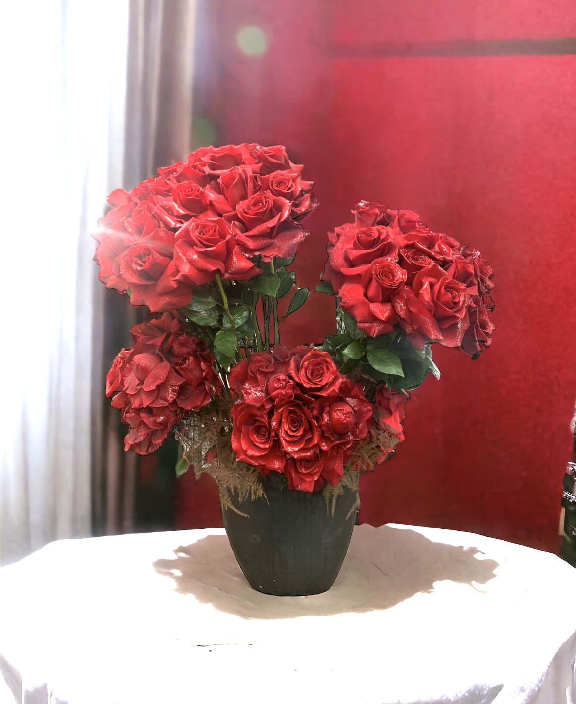 Black swan - Flower: Designed in a grouping  with 75 red roses. Vase : 12&quot; by 12&quot; oval shaped black vase, the overall creation stands at 28”by 22” 