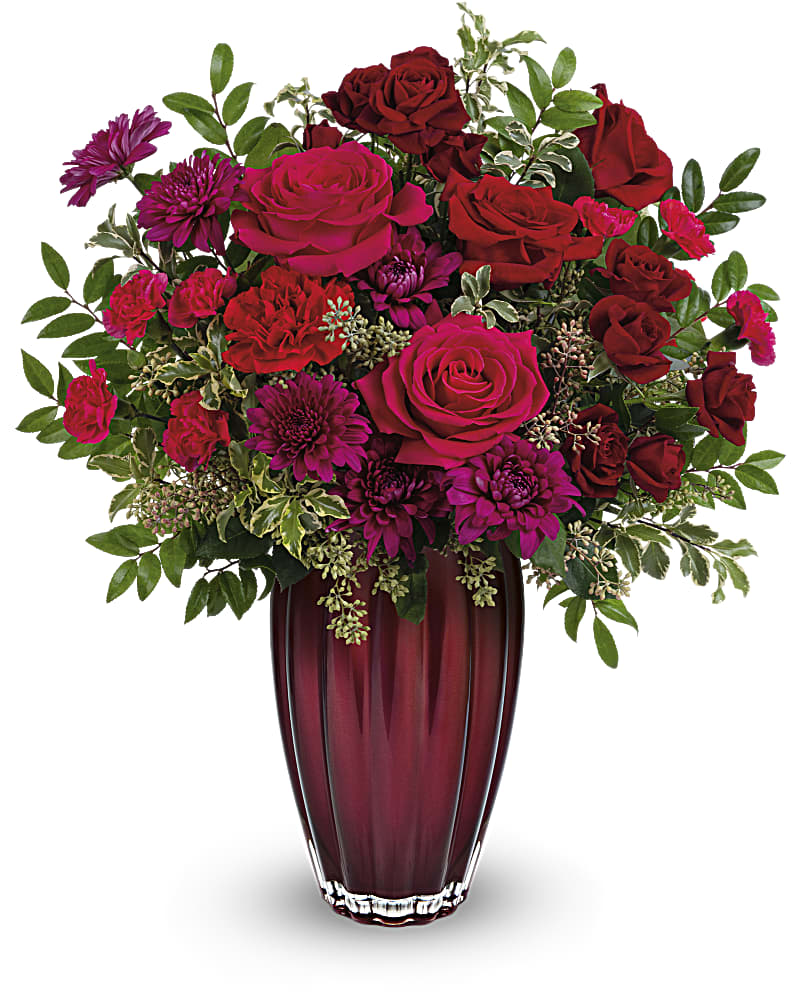 Modern Lovely Bouquet - Two glorious gifts in one, this beautiful rose bouquet looks absolutely breathtaking in a sleek, shimmering vase of European glass. This bouquet features red roses, hot pink roses, dark red spray roses, red carnations, miniature hot pink carnations, purple cushion spray chrysanthemums, huckleberry, pitta negra and seeded eucalyptus. Delivered in a Modern Devotion vase.