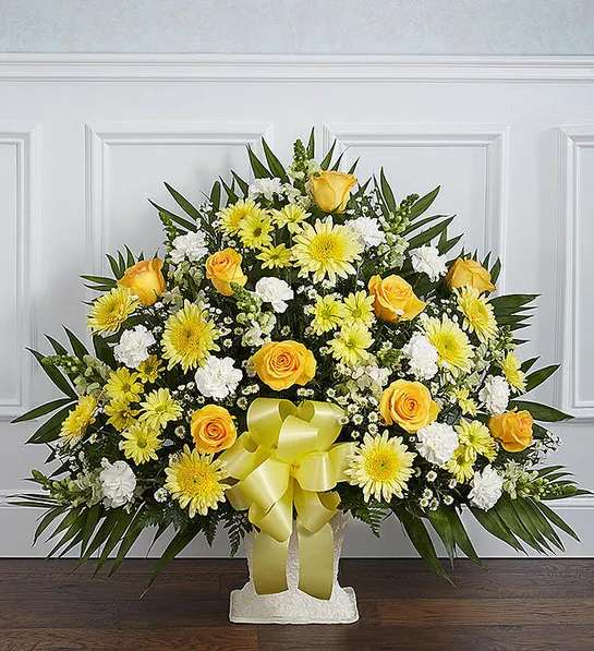 Yellow Floor Basket Arrangement - ometimes a small ray of hope is just what is needed to get through the difficult days following the loss of a loved one. Our elegant floor basket arrangement in sunny hues, handcrafted by our caring florists with warm yellow and white blooms, is a tasteful gesture perfectly suited for the funeral home or memorial services.