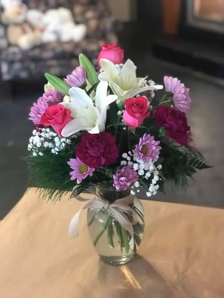 Well Wishes - Designed at our flower shop with lilies, roses, carnations and sweet lavender daisies