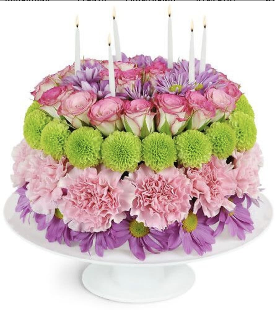 Let's Celebrate - Celebrate in full bloom with our Rainbow Birthday Cake! This arrangement of roses, daisies, buttons, and carnations are carefully arranged in the shape of a classic birthday cake with candles. Perfect for those who enjoy the beauty of nature and the sweetness of life, whether they are 7 or 70.