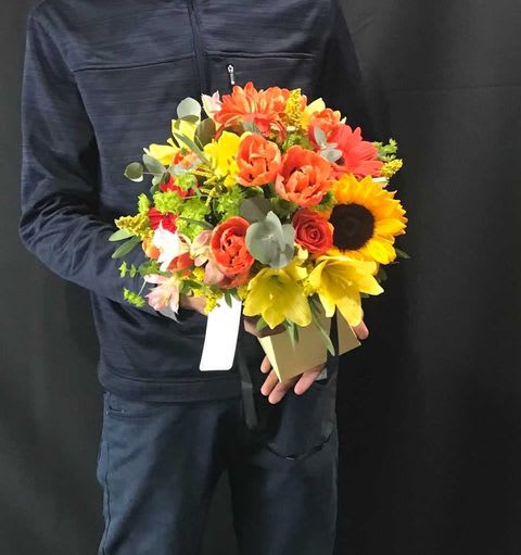 Gloria - A soft wrap bouquet of vibrant yellows and oranges. Just looking at the bouquet is enough to remind you of the warm feeling of summertime.