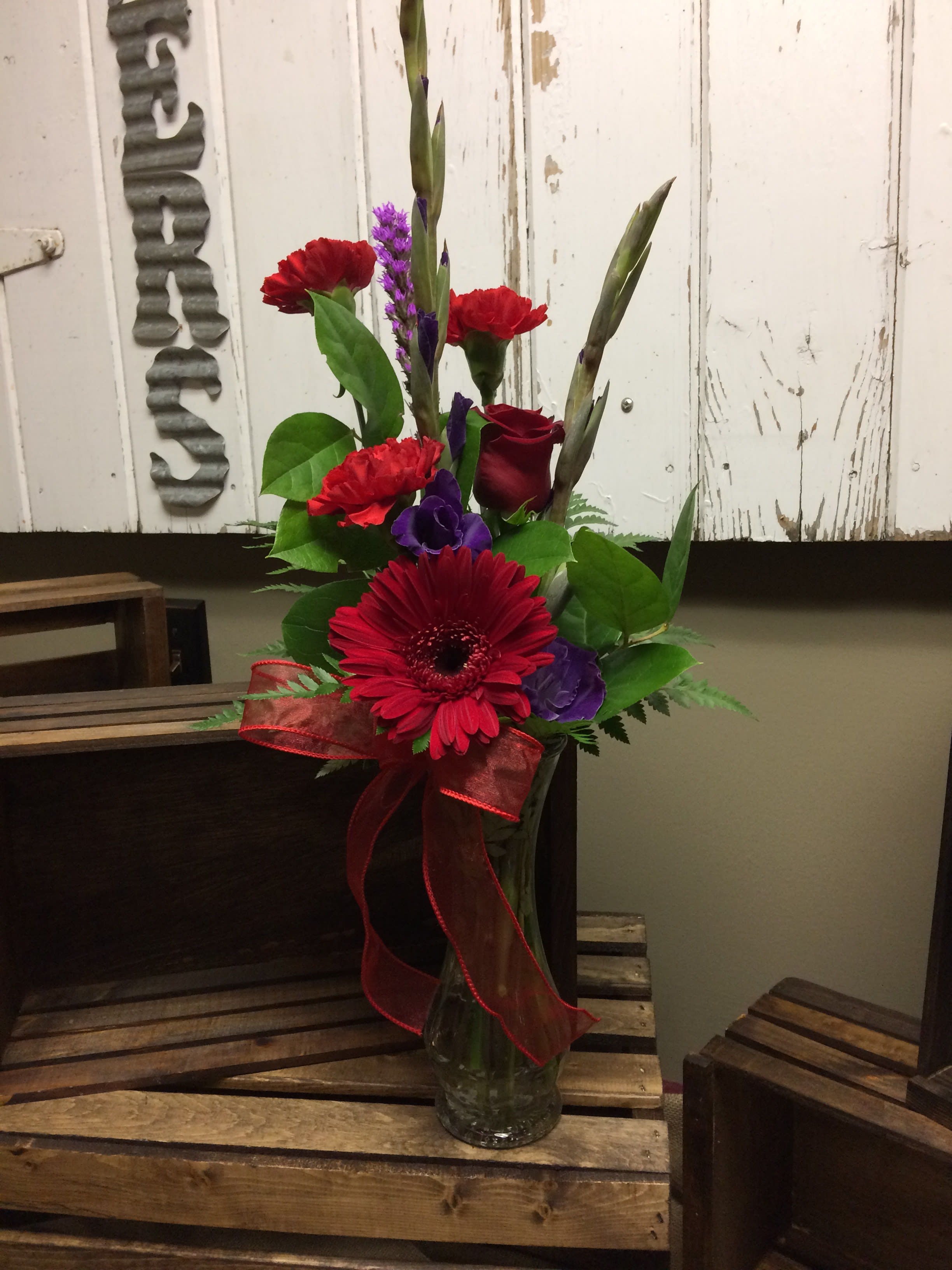 Happy Go Red! Custom Design by Cold Spring Floral - Happy Go Red is an arrangement with bright colored Gerbera Daisies, Liatris, Carnations, Gladiolas and Roses with assorted Greenery in a vase. Colors and flowers may vary based on availability and are subject to substitution.