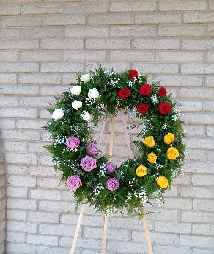 Graceful Tribute Wreath -  Graceful Tribute Wreath creates a stunning presentation  of love's serenity for their final farewell. Roses carnations, greens,baby breath and spray roses accent this beautiful wreath. 