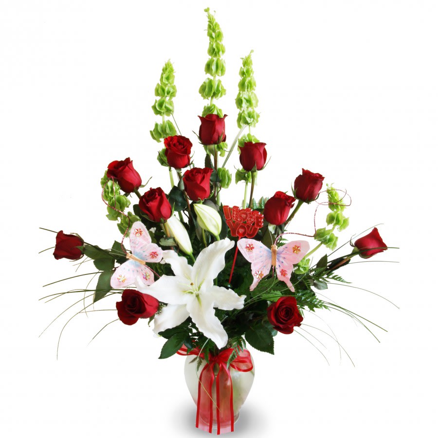 Mi Amour - Show your love with our &quot;Mi Amour&quot; floral arrangement featuring an appealing bundle of a dozen red roses, lilies, and more!  The arrangement is supported by an opalescent vase decorated with a red ribbon.