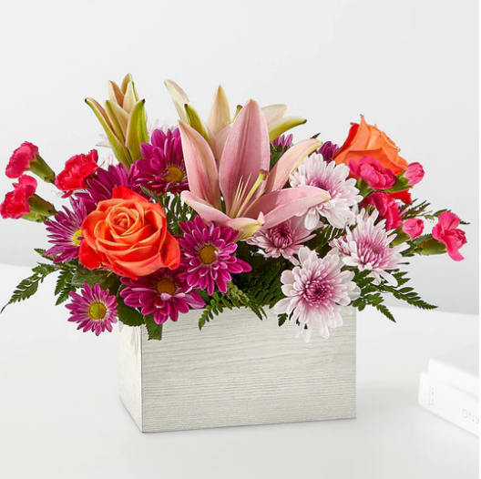 Light Of My Life Box - From life's big moments to sweet just because sentiments, the Light of My Life Box Bouquet is designed to celebrate your loved ones any day of the year. RSVP'd to the party are hot pink carnations, orange roses, lavender cushion poms and lush greens.