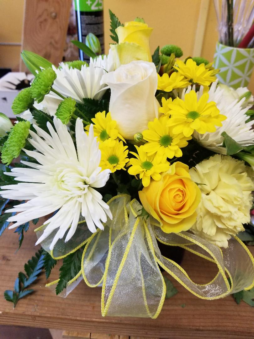 YELLOW/WHITE SYMPATHY CUBE YELLOW/WHITE SYMPATHY CUBE - 3 white and 3 yellow roses with spider mums and yellow and white carnation, and other fillers.