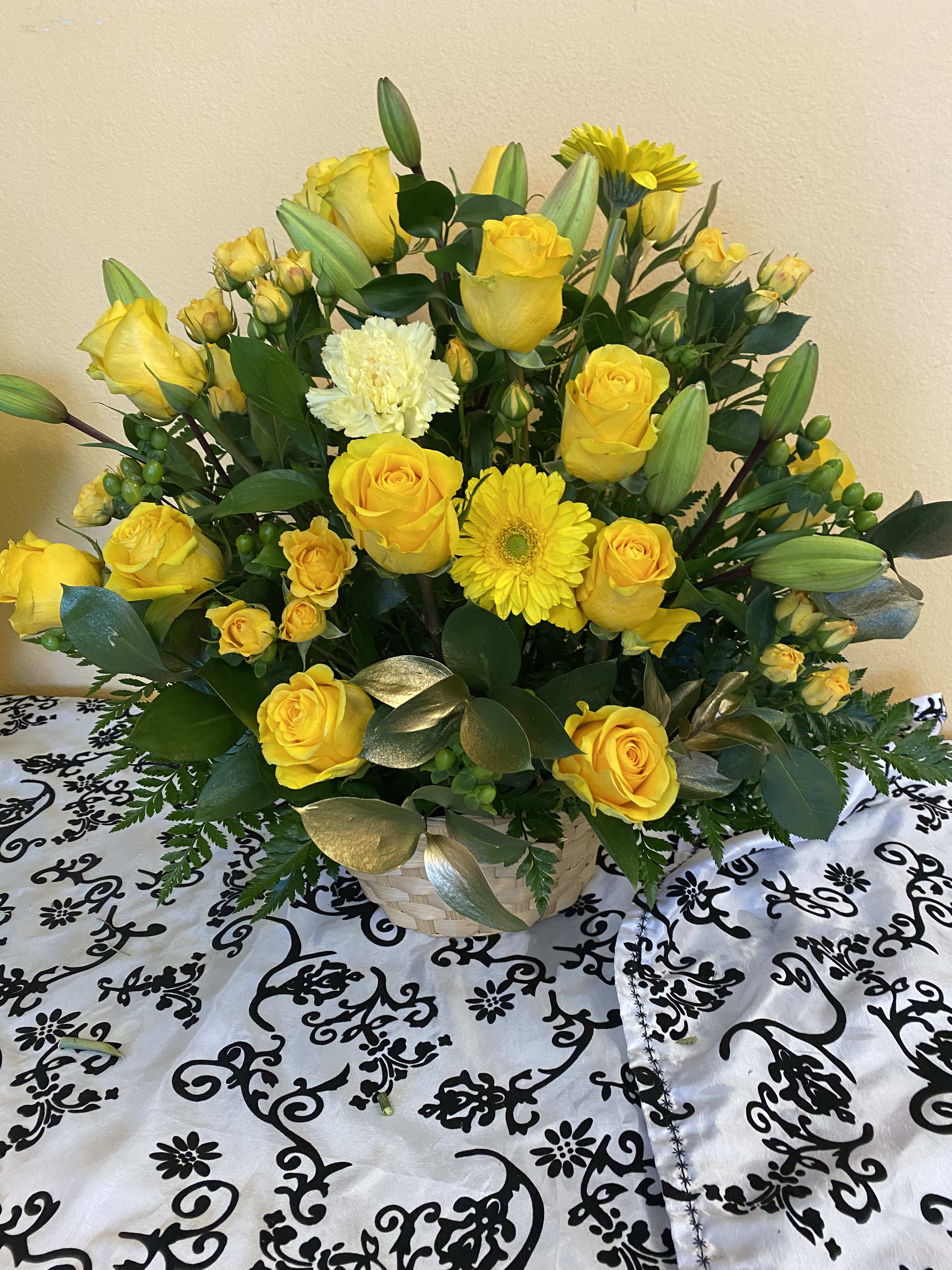PLEASE SMILE BASKET PLEASE SMILE BASKET - A MIXTURE OF YELLOW FLOWERS WITH A TOUCH OF GOLD RUSCUS IN A BASKET. FLOWERS TO INCLUDE ROSES, SPRAY ROSES, CARNATIONS, GERBER DAISIES AND LILIES.