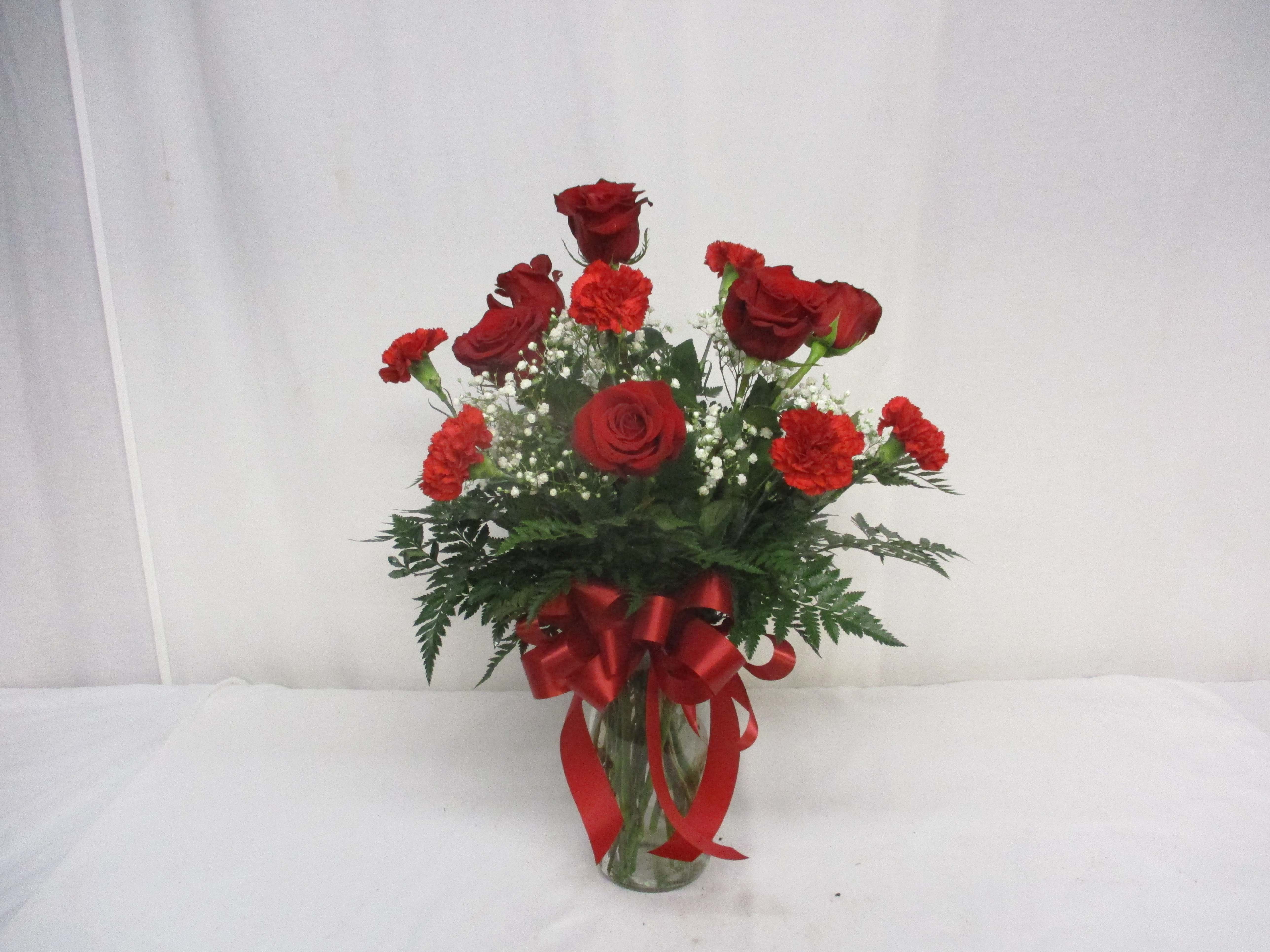 Lots O' Love - This beautiful display contains and even dozen of red blooms, half roses and half carnations, topped off with a heart of Love.