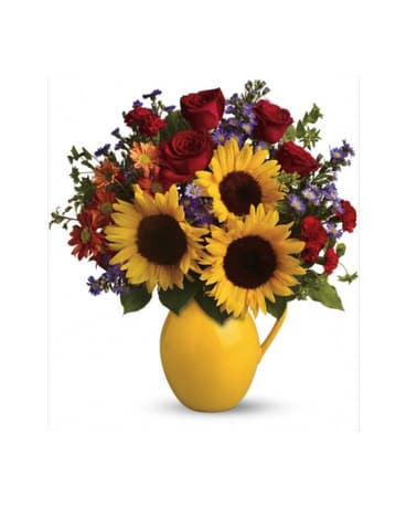 Sunny Day Pitcher of Joy - Sunny sunflowers, red roses and miniature carnations, bronze daisy spray chrysanthemums, large lavender monte cassino asters and autumn greens are beautifully arranged in a ceramic pitcher.  Flowers and colors may be substituted depending on availability.   FCF-TFL01-1