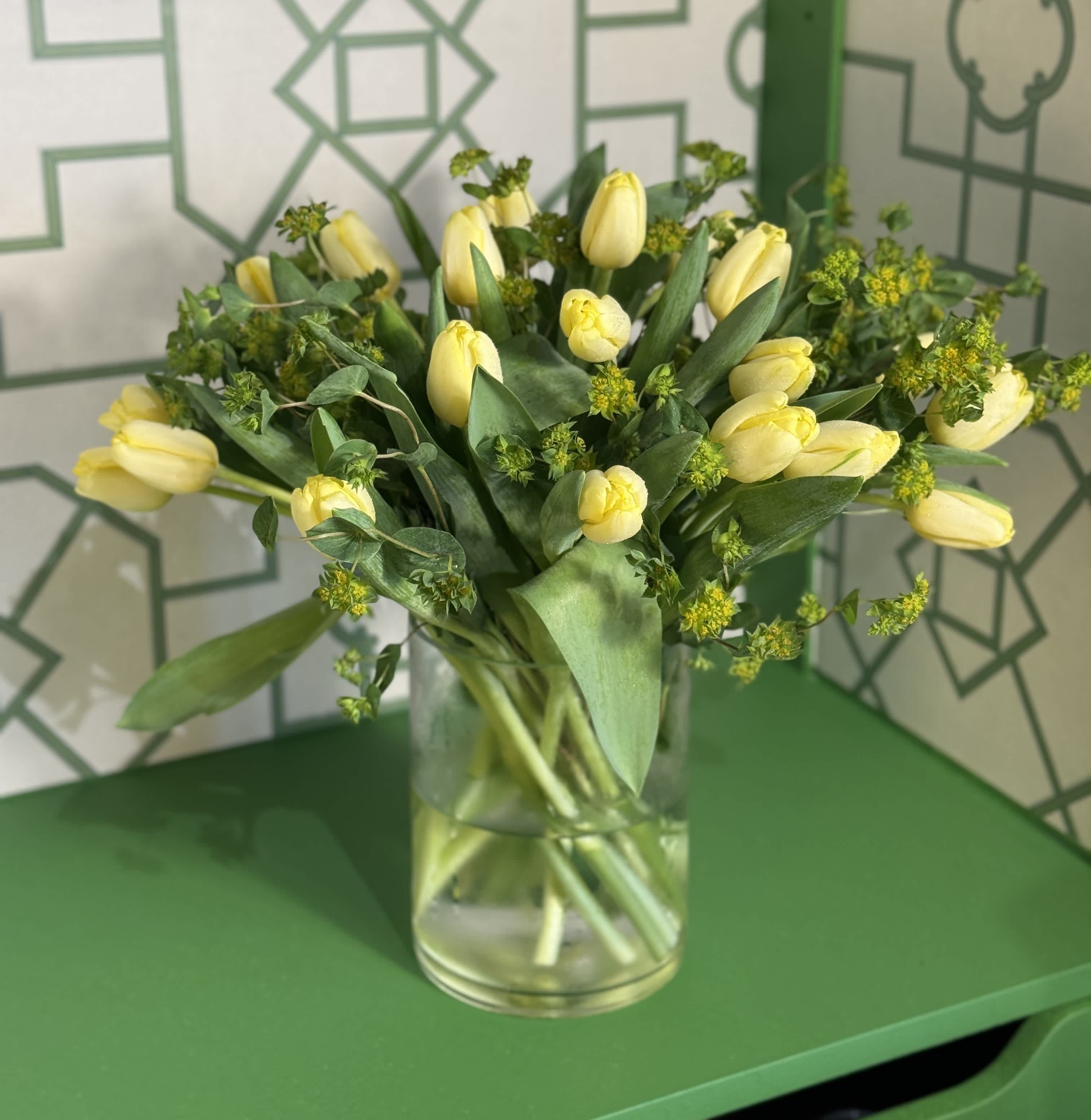 Mellow Yellow - An elegant vase arrangement filled with 20 yellow tulips imported from Holland.   *Shade of yellow may vary* *Deluxe price includes 40 yellow tulips*  At Belden's Florist we stand behind the quality of our products. We guarantee that our flowers will remain fresh and beautiful for 3-5 days after delivery. As cut flowers, they may naturally start to wilt beyond this timeframe. However, we ensure that you receive the freshest blooms possible, carefully selected and expertly arranged to bring joy and elegance to your space. To help your flowers stay fresher longer, we recommend adding fresh water to the vase regularly. Just like you, flowers need hydration to thrive, and refreshing the water allows them to drink up and continue to dazzle you with their beauty.