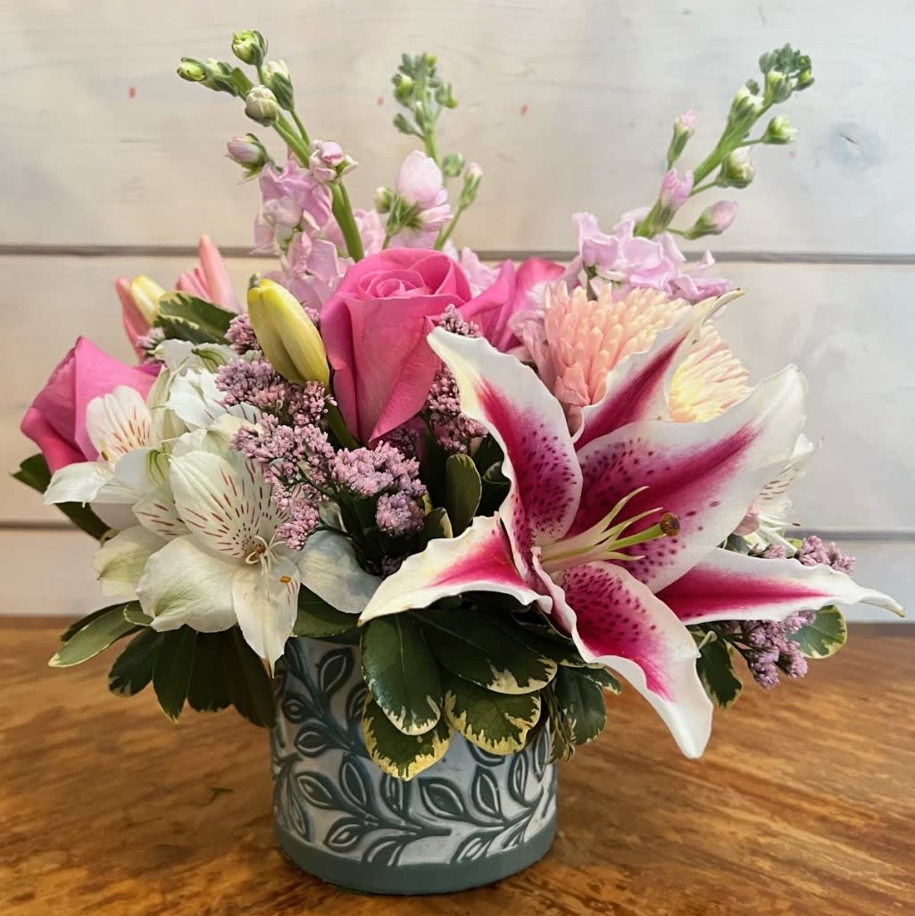 Maternal Love - Pink roses, pale pink stock, pink chrysanthemums, stargazer lily and white alstroemeria arranged in a small ceramic pot with laurel leaf design and pink misty. Approximately 10in tall and 10in wide.   
