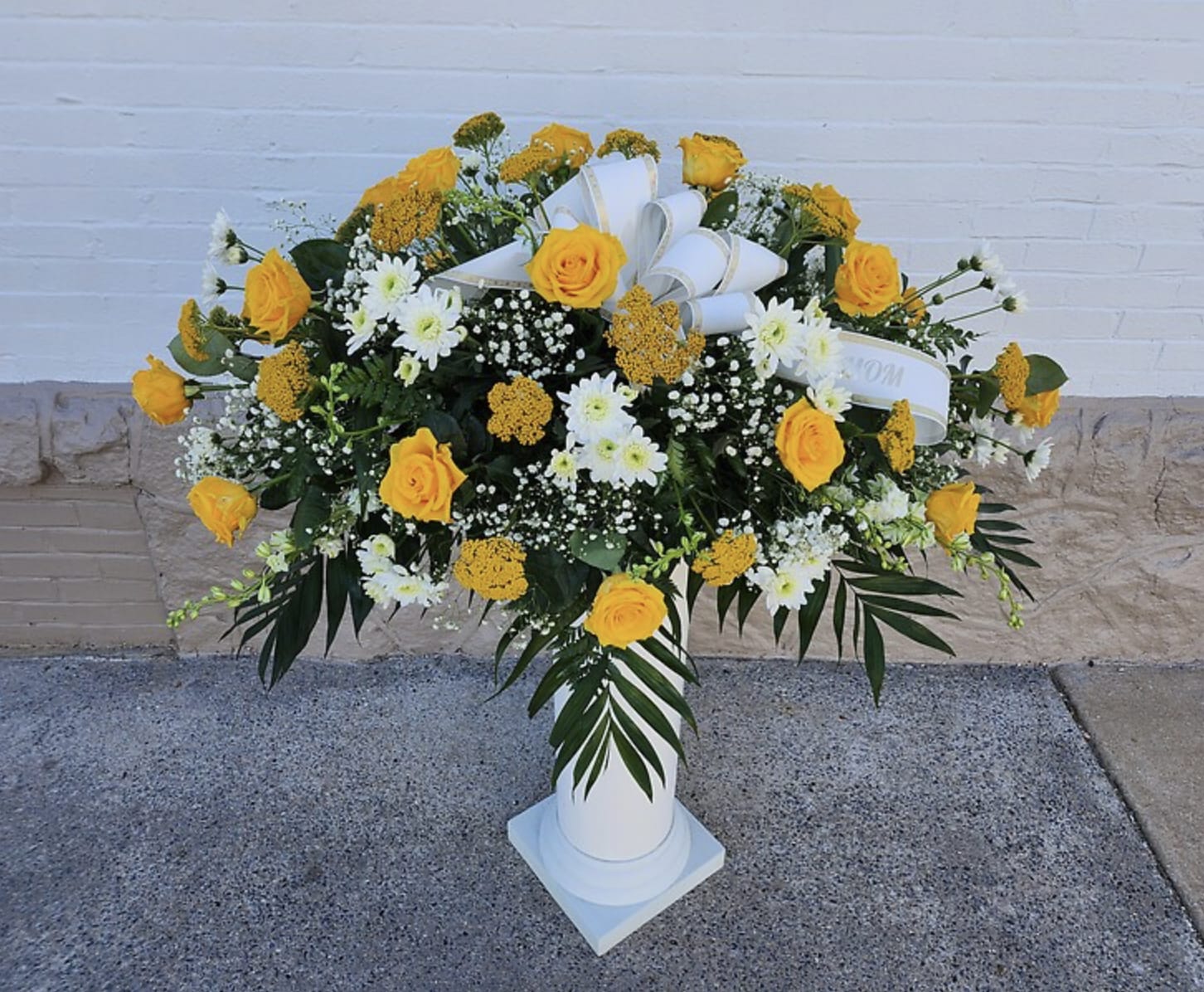 Treasured Tribute Casket Spray - Honor their generous spirit with a blanket of sweetly yellow and white flowers that create a magnificent final tribute, sincerely expressing devotion and love.  (Only available in pink, red, purple, and yellow variations.) 
