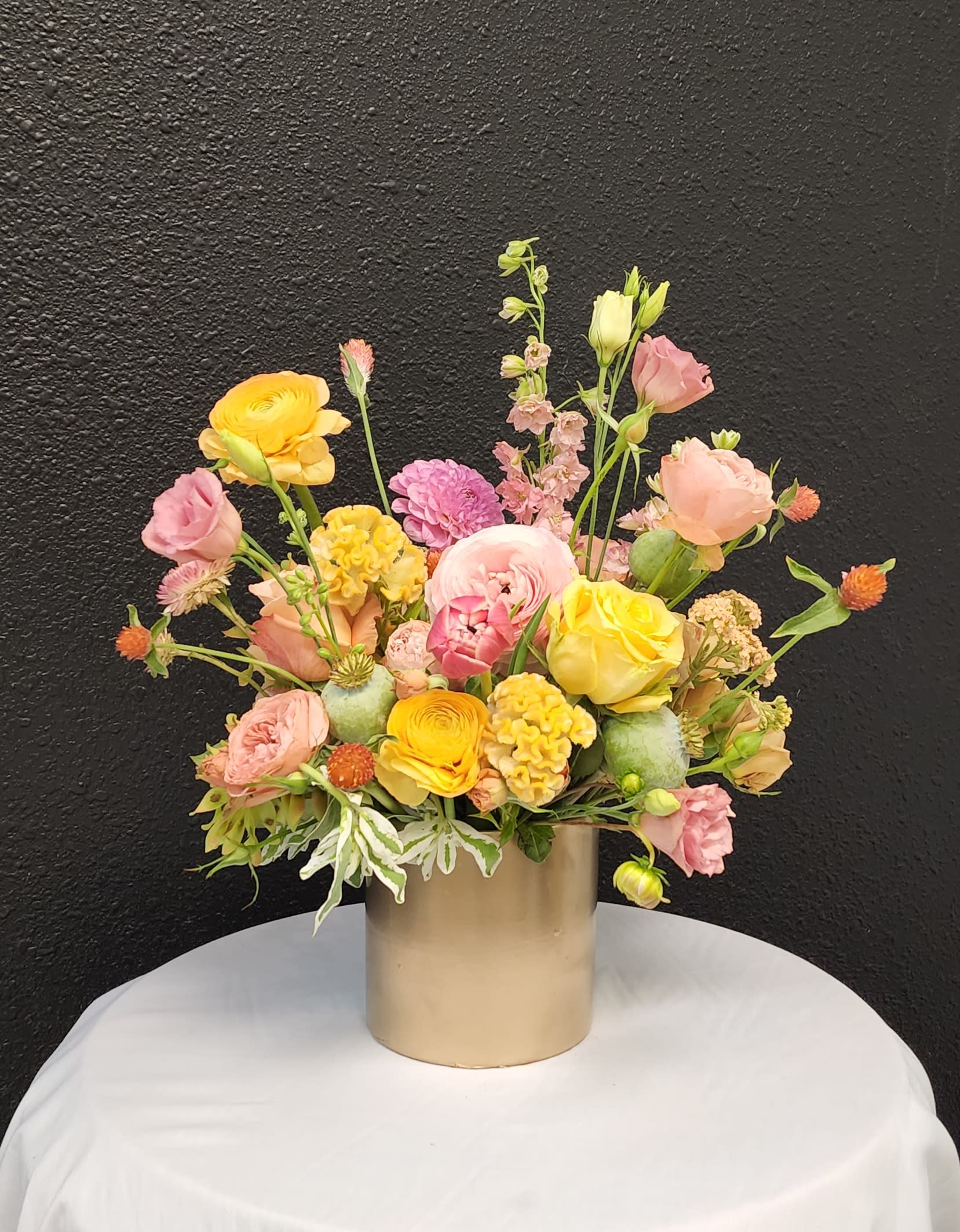Summer Glow - Lovely Pink, Peach and Yellow Blooms arranged organically in a gold cylinder. 
