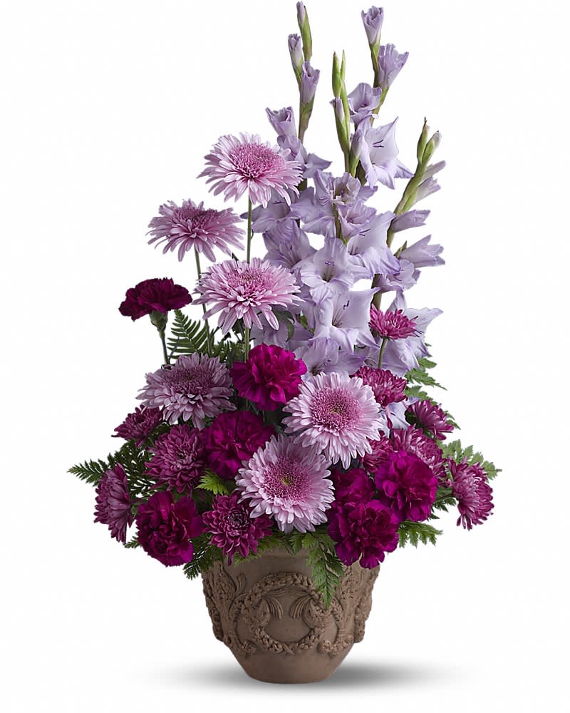 Teleflora's Heartfelt Memories - A towering display of blooms such as gladioli carnations and chrysanthemums in royal hues of purple and lavender presented in a Grecian-style urn is a gracious representation of your heartfelt sentiments at a funeral memorial service or wake. A mix of fresh flowers such as gladioli carnations and cushion spray chrysanthemums in shades of lavender and purple - accented with ferns - is delivered in a Teleflora Garlands of Grace urn.