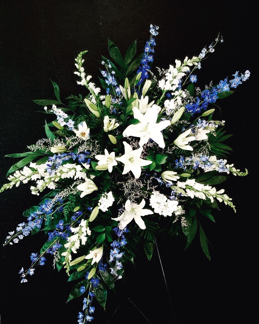 On The Wings of Angels  - This tribute is an elegant display of Lilies, Delphinium, Stock and other flowers. 