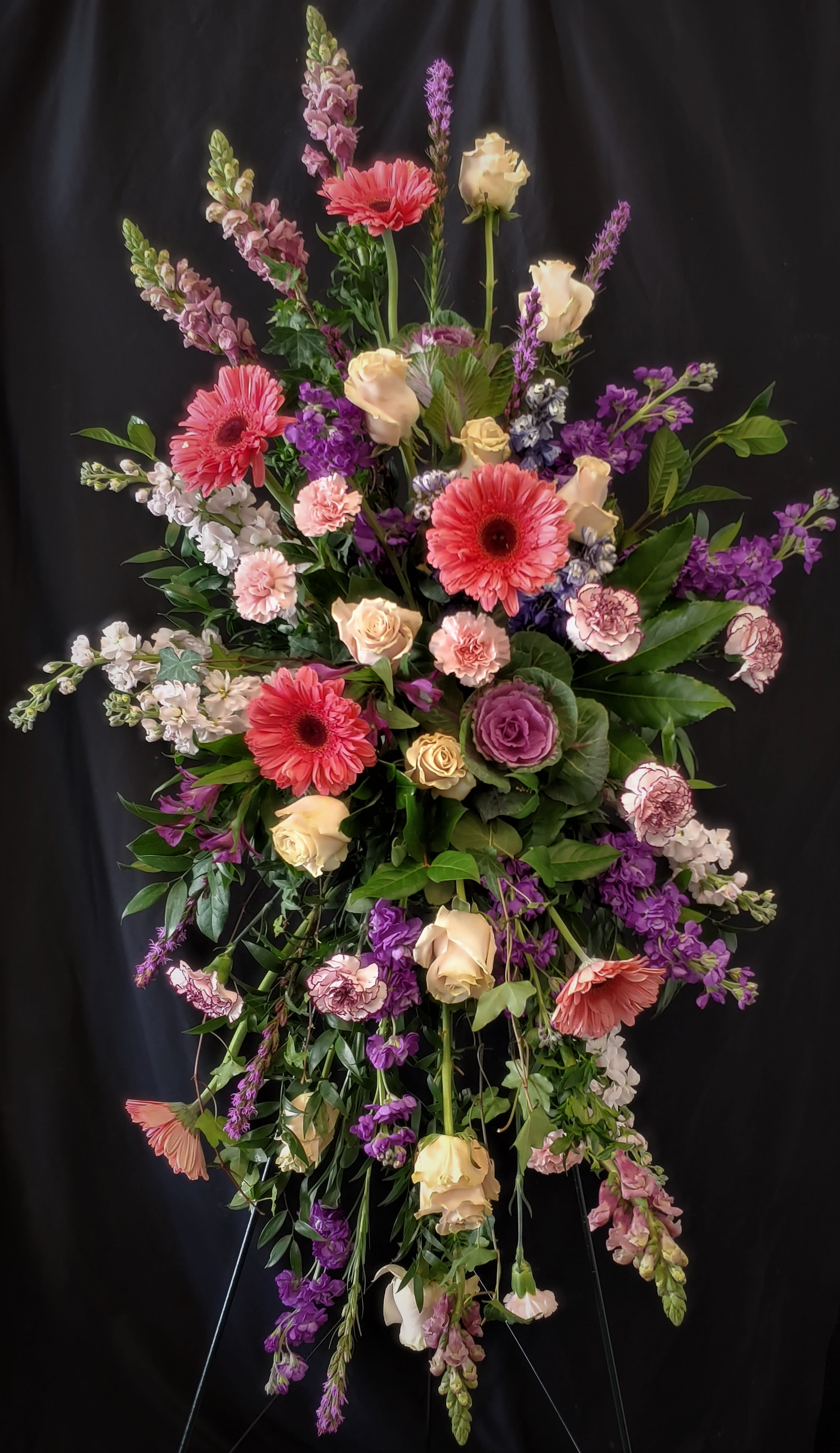 Spring Memories Tribute  - Creating a beautiful and unique tribute for a loved one is always a meaningful way to honor their memory. This striking standing floral tribute features shades of pink and purple, and is the perfect way to express your love and compassion. The beautiful blooms are arranged to form a touching standing tribute, making it the perfect choice for a funeral or memorial service.
