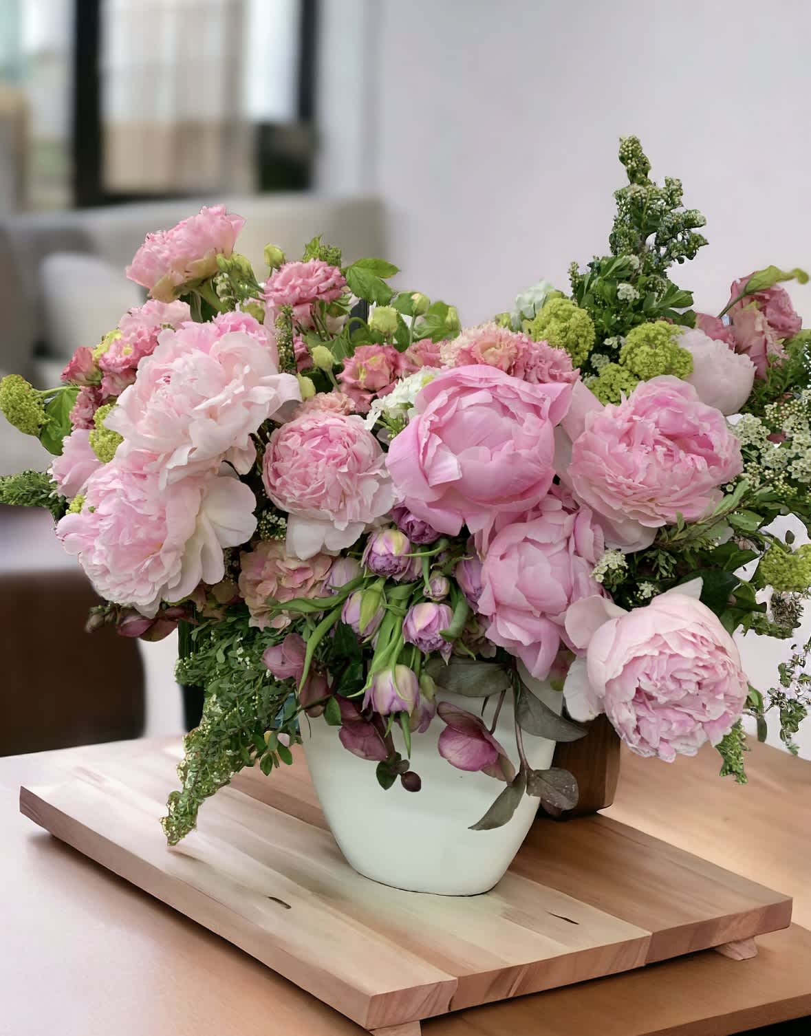 Peony lover - A medley of peonies and Lisianthus, winter roses meet whimsical tulips.  Resting inside a 7” x 7” vase, the arrangement stands overall 14” tall and 14 wide. 