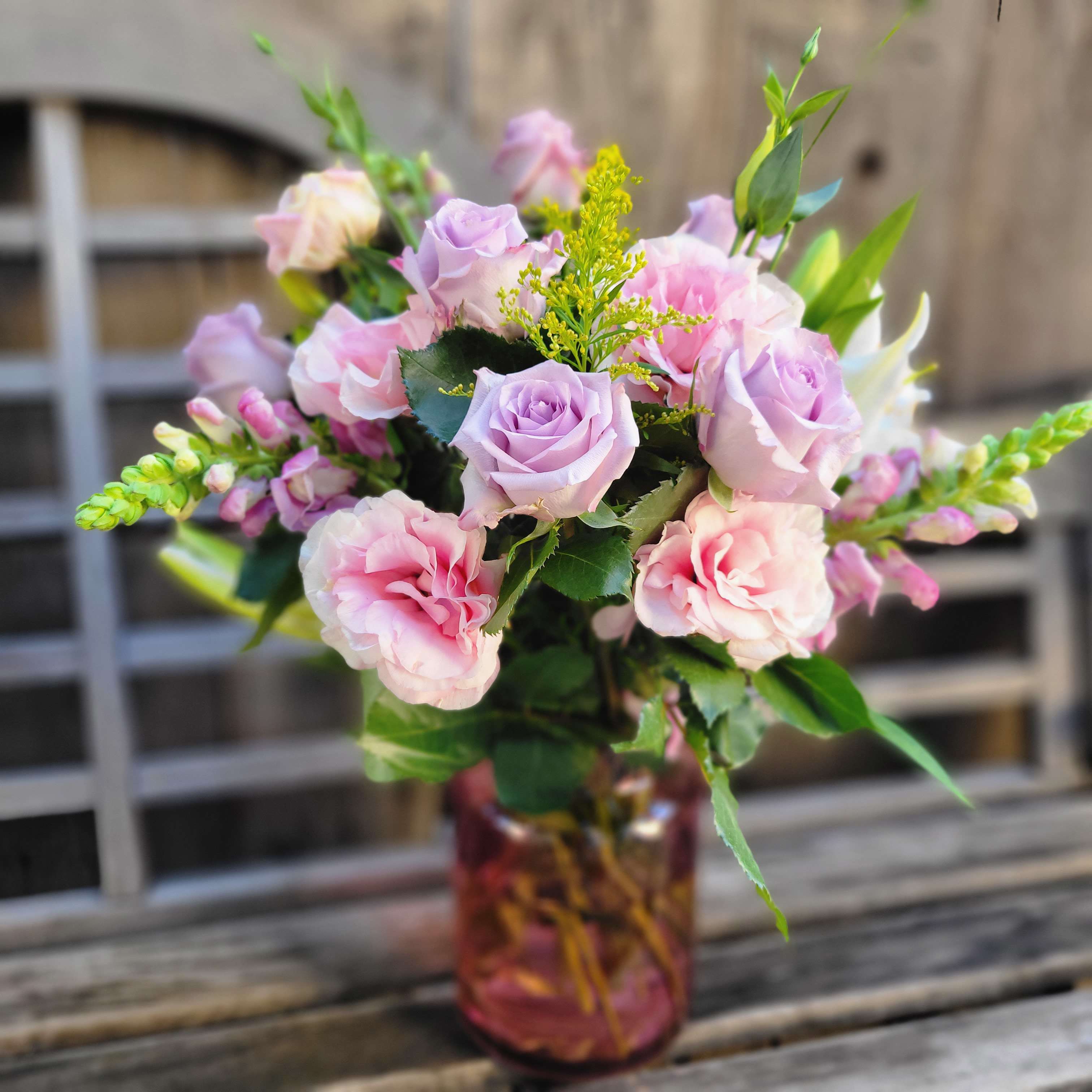 Lovely Lavender - The lovely Lavender Bouquet is one of our premium arrangements, It features lavender roses, Lasianthus, Snap dragons, and lilies, as well as supporting greenery. Presented in the Blush vase!