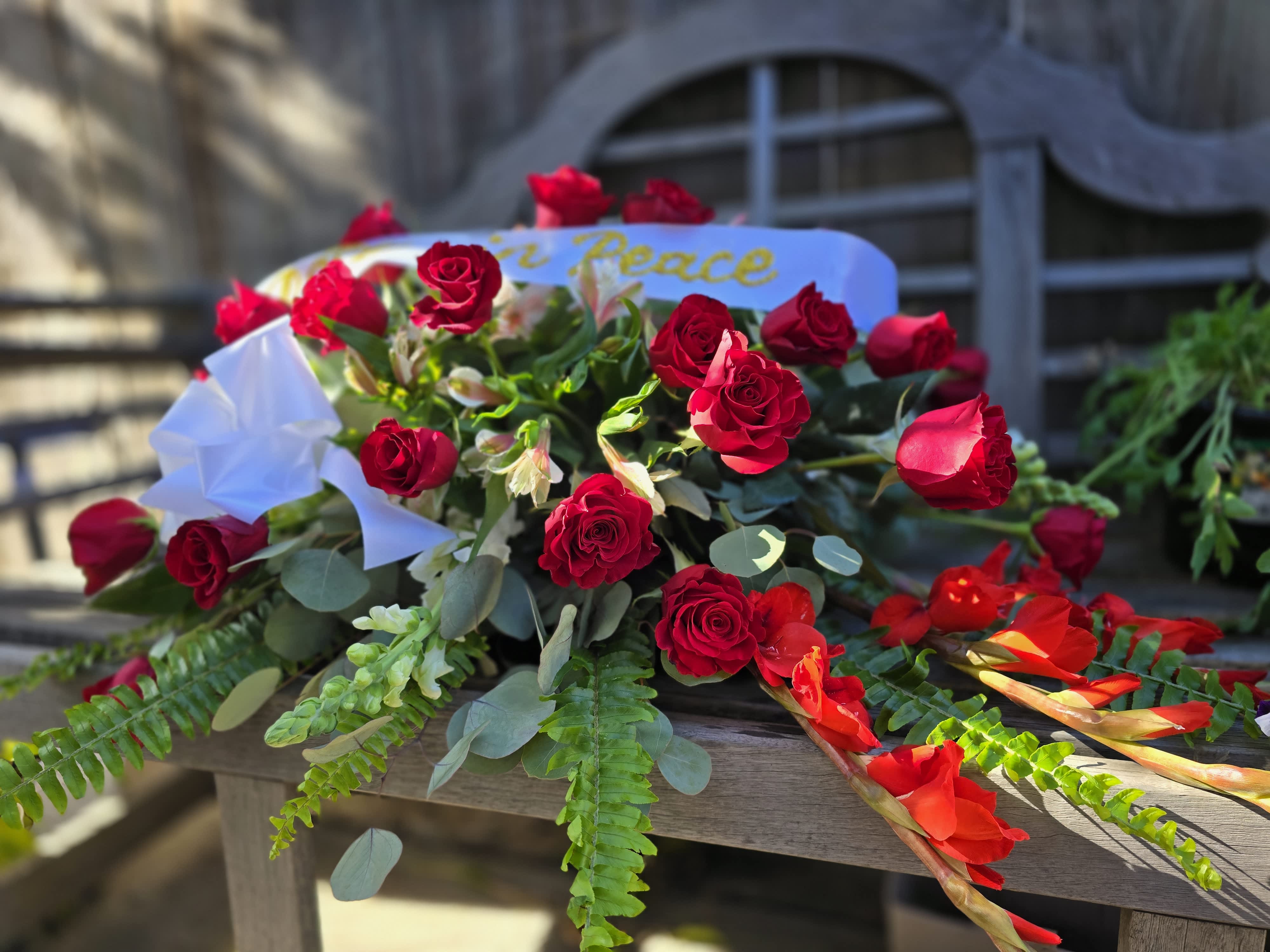 Red Rose Remembrance - This Casket spray features red roses, red gladiolas, fern leaf, &amp; Eucalyptus.