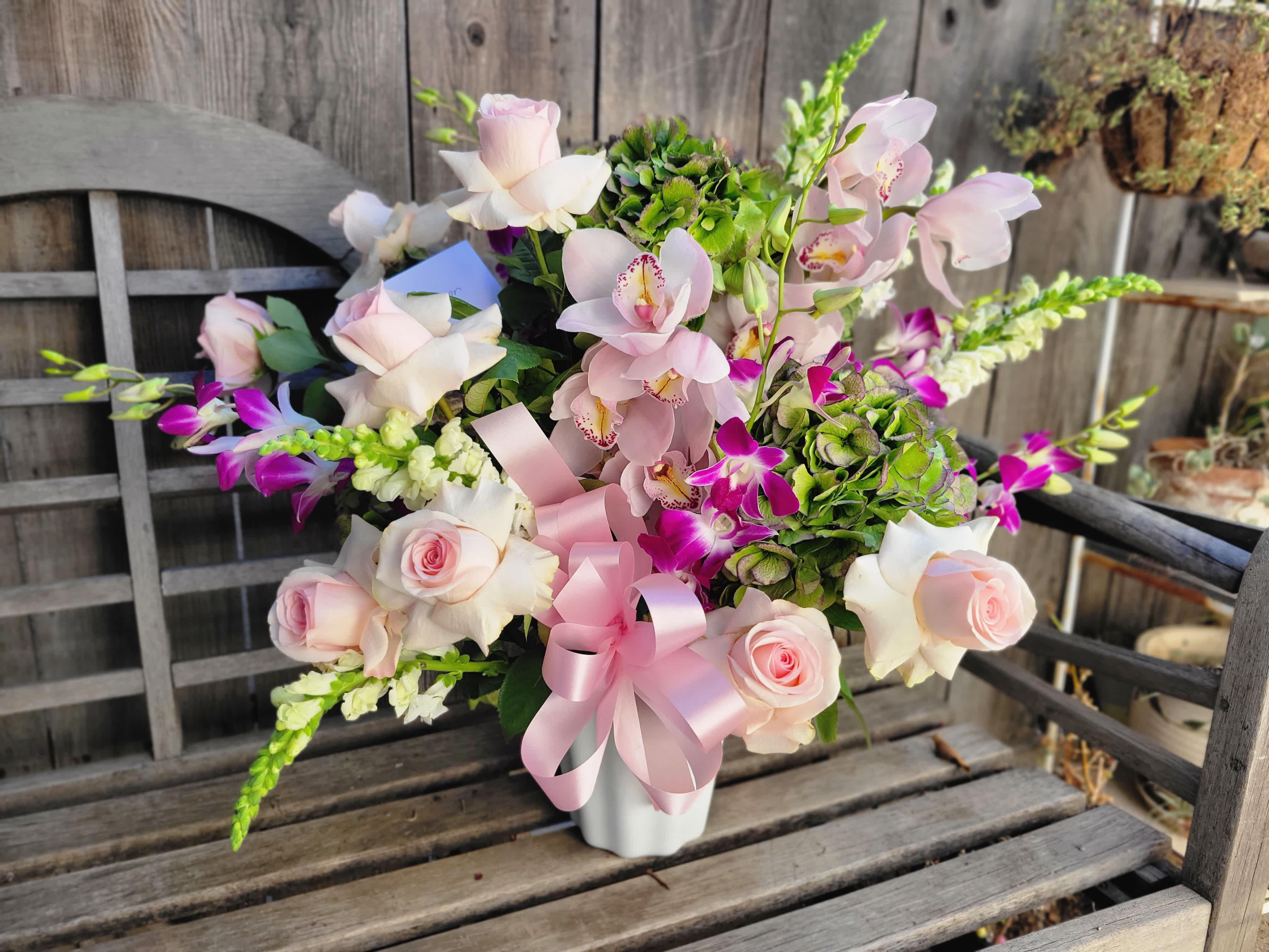 Ethos Embacy - This arrangement features premium multicolor Hydrangea from Holland, Cymbidium Orchid, Dendrobium Orchid, Pastel Roses, and Snap dragons. It arrives presented in a white basket