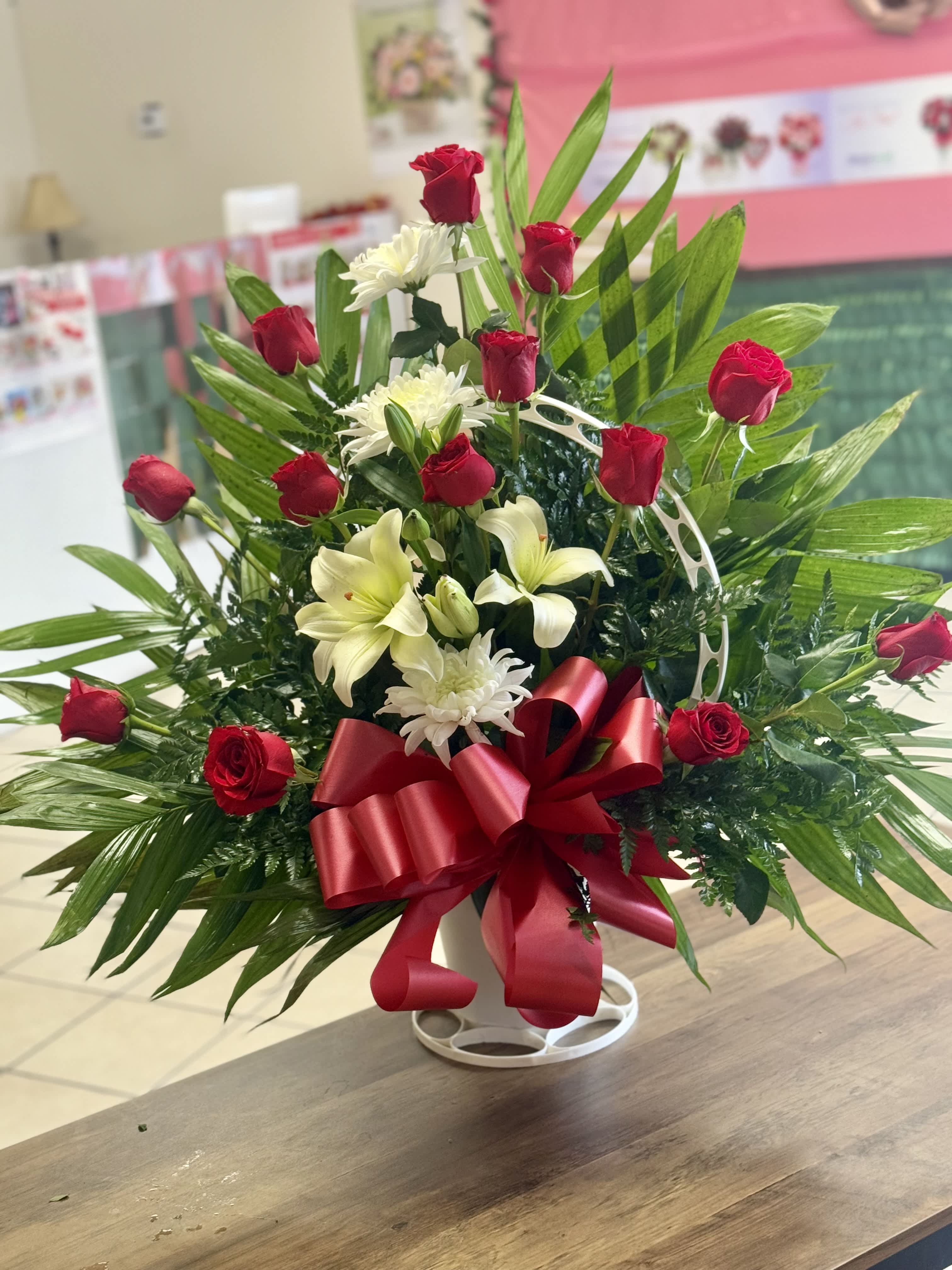 White and red standing basket - A beautiful standing basket arranged with red roses and white lilies in a traditional funeral basket. Picture shown is for Premium Price 