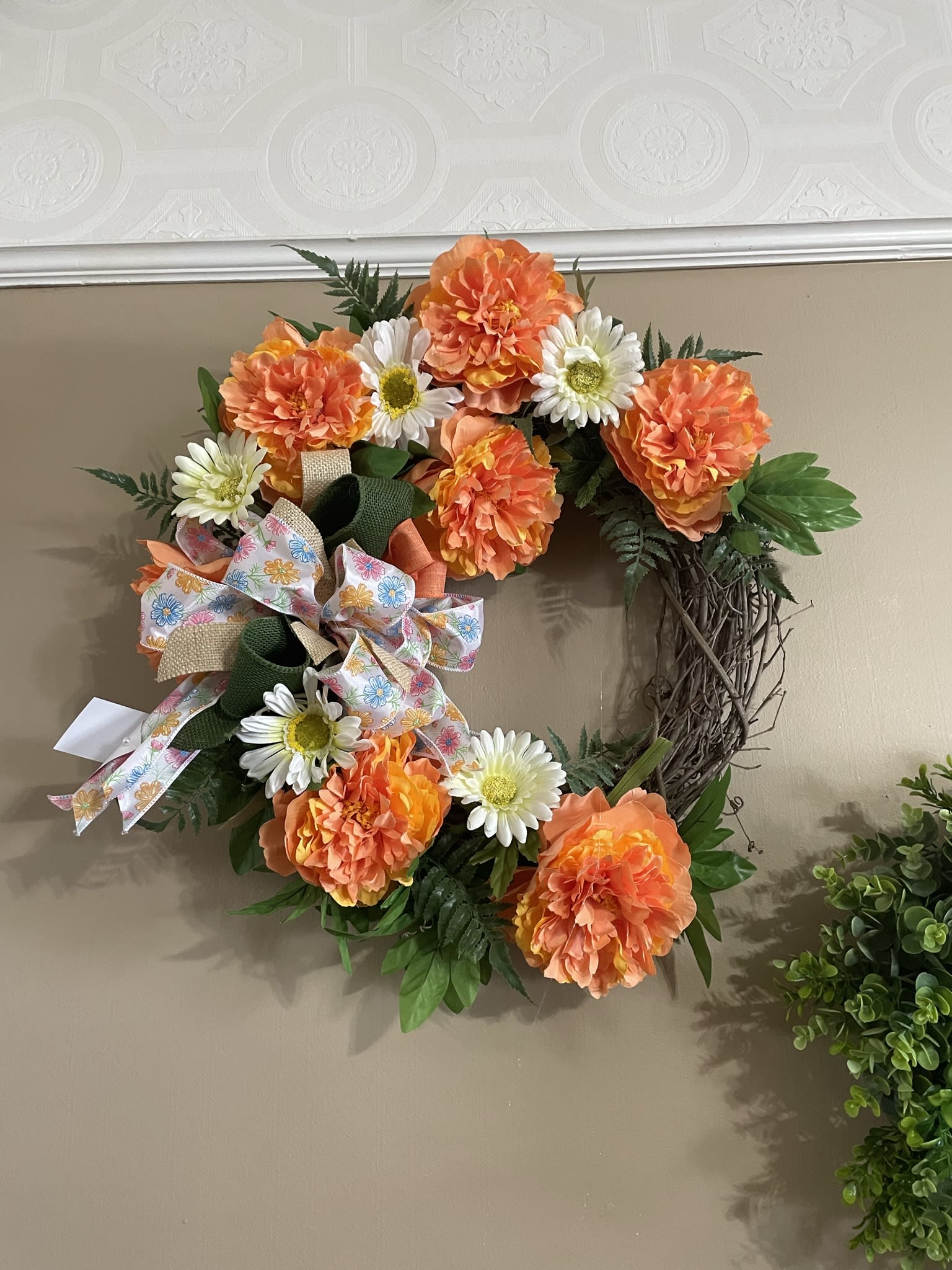 Bright Spring Silk  Grapevine Wreath  - A grapevine wreath completely covered in various shades of cream, peach and orange silk flowers,  mixed ribbon and green ivy vines.