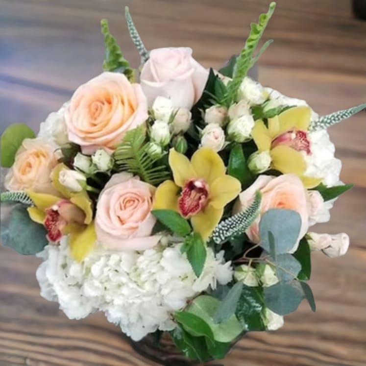 Peaches and Cream By Parisian Florist - Beautiful is what they will say when they see this lovely peach and cream arrangement filled with roses, hydrangea, and orchids designed in a glass cylinder.