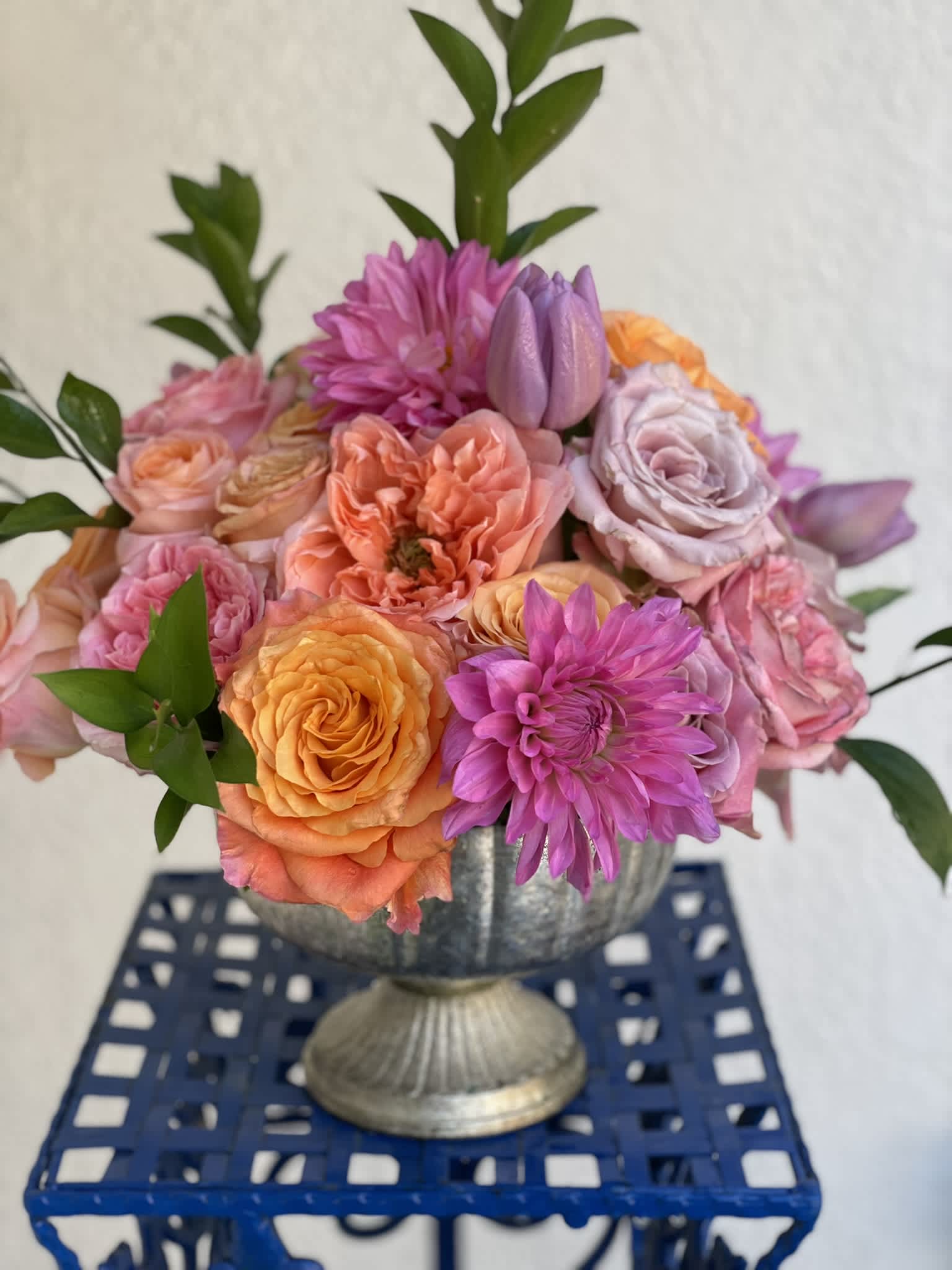 Hot and Bright  - This striking arrangement is anything but dull! The bright and bold color palate reflects the colors of spring and summer, conjuring thoughts of bustling gardens full of summer blooms. The various textures of the garden roses, dahlias, and tulips give this combination an elegant and soft look. 