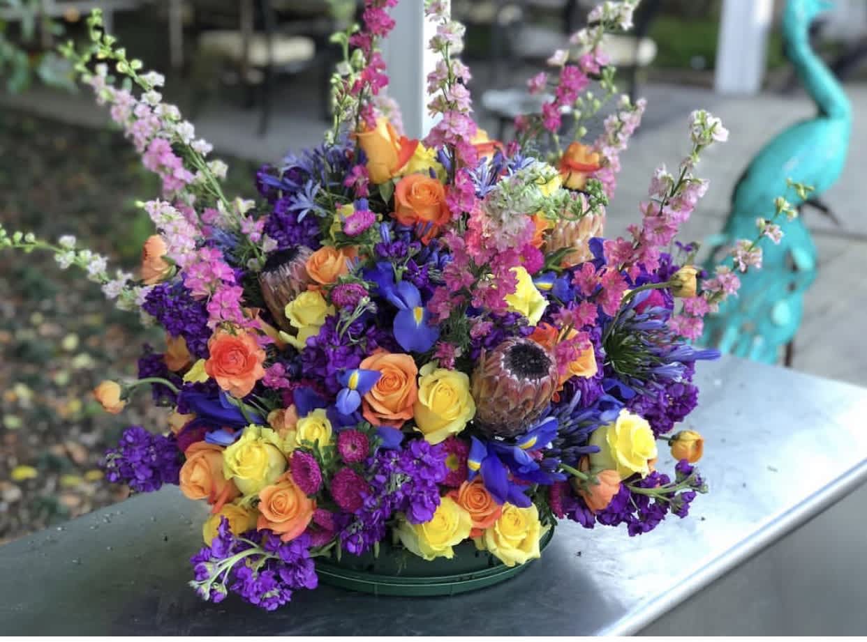 Vivid and Vivacious - This vivid and eye-catching arrangement is built to be the center of attention in any room or any event. The variety of shapes and colors bursting from this collection make it a show stopper. And with no greenery or filler, the blooms truly are the star of the show!   *Premium Arrangement Pictured 