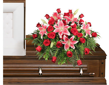 Dedication Of Love - Marked with deep love and exceptional beauty, our designers have assembled a casket arrangement to honor your loved one. We have taken great care in hand selecting elegant red roses and starfighter lilies to create an arrangement that expresses a love that can not be put into words.