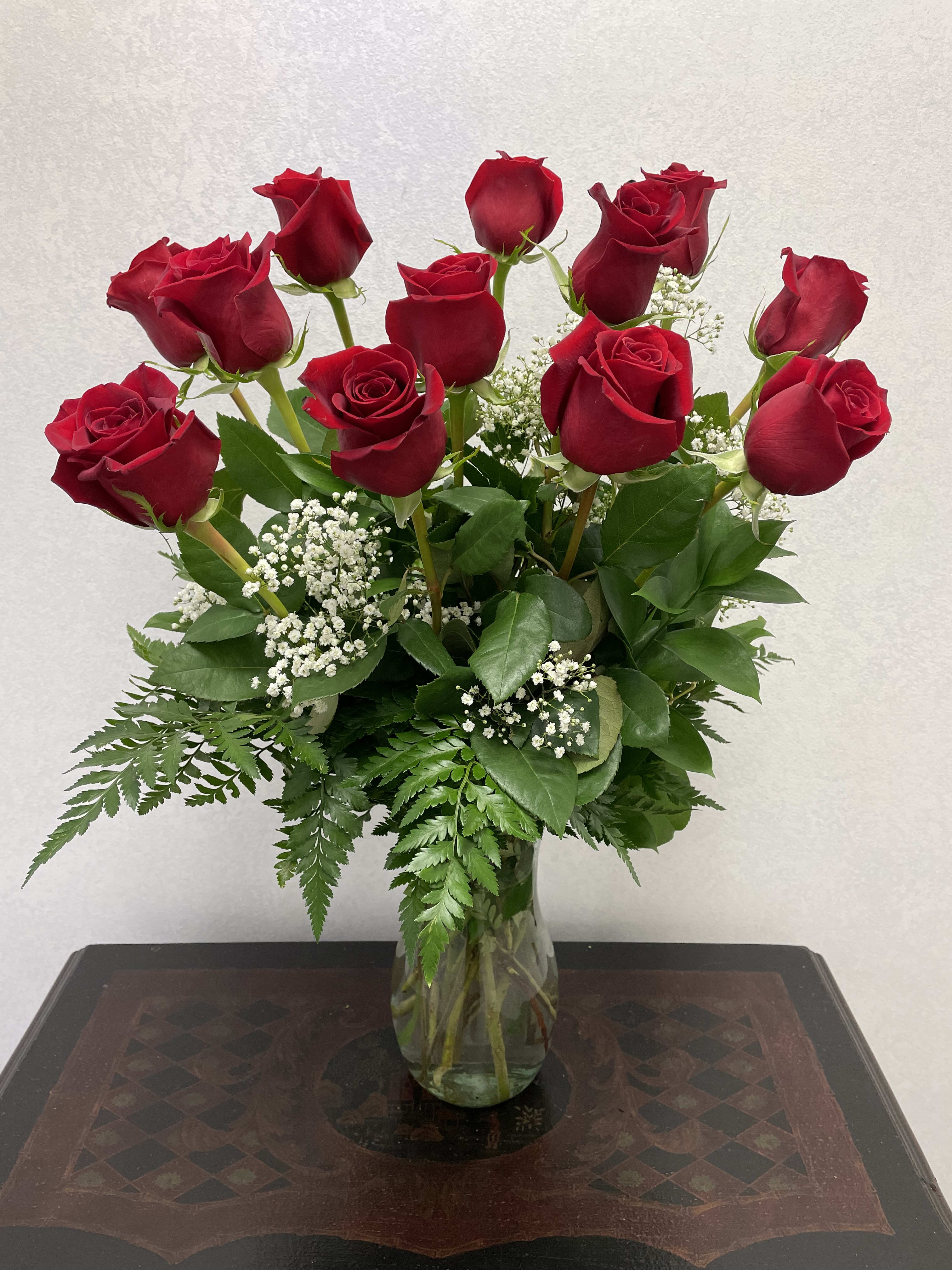 Red Rose Masterpiece - The Red Rose Masterpiece bouquet is a classic expression of love and affection. A bouquet of 12 red roses accented with lush greens, all beautifully arranged in a clear glass vase.