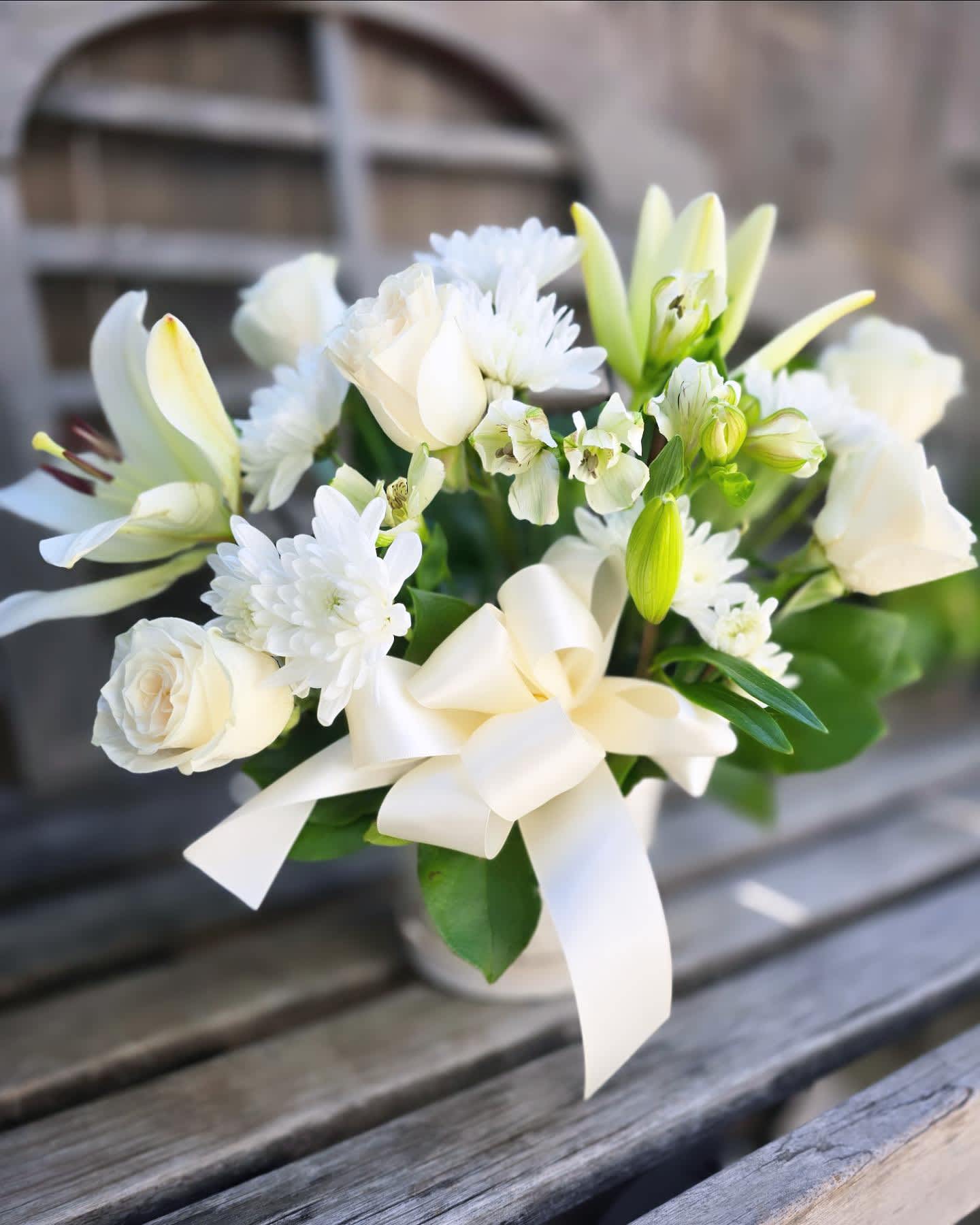 Lasting Friendship - &quot;Lasting Friendship&quot; is an all white sympathy bouquet for the home. This arrangement features all white florals such as: roses, Lily, Alstroemaria, and daisy or Daisy pom. Presented in a white ceramic container. This arrangement is ready to arrive straight to your loved one's doorstep with same day delivery.