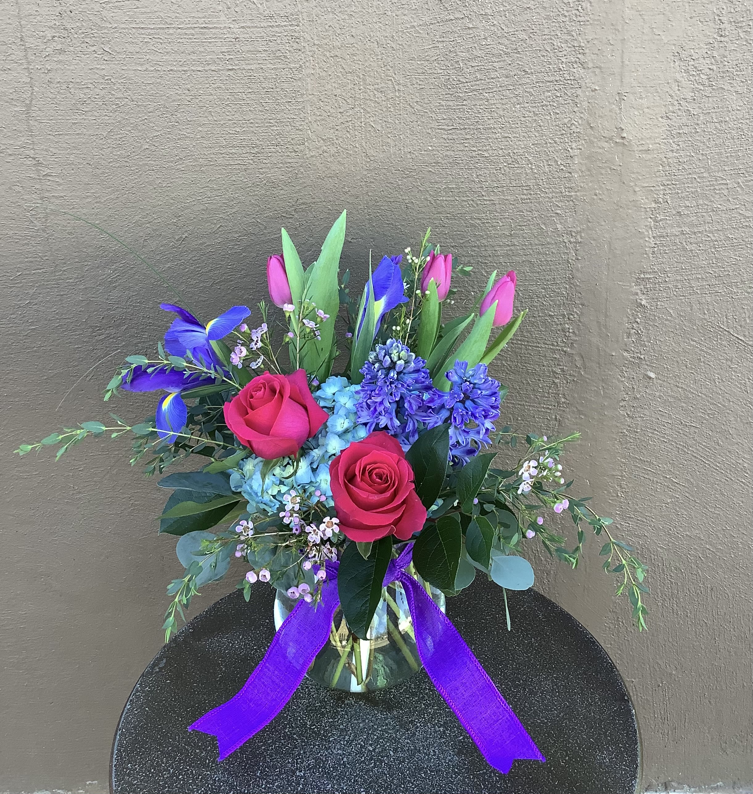 Spring Jewels - This jewel-tone spring arrangement is filled with spring bulb flowers, tulips, iris, and hyacinth, along with vibrant roses and hydrangea. Definitely the crown jewel of spring! 