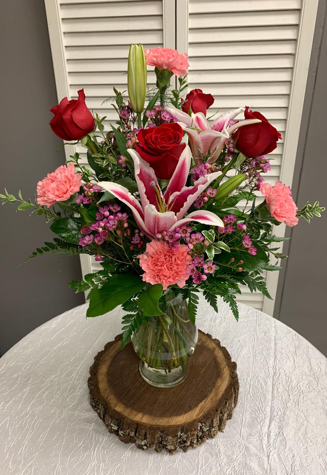 I Adore You Arrangement - This arrangement includes Red Roses, Stargazer Lily, Pink Carnations and Wax Flower. Lily color may vary from photo.