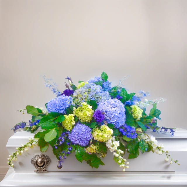 Azure Serenity Casket Spray Azure Serenity Casket Spray - Our Hignight's exclusive design, the Azure Serenity Spray, is a breathtaking arrangement that showcases the beauty of hydrangeas in shades of blue and green, elegantly complemented by the delicate blue delphinium blossoms. Each flower is hand-selected and expertly arranged to create a soothing and serene tribute to your loved one. Whether you're looking for a heartfelt expression of sympathy or a comforting tribute, our fresh flower casket spray with hydrangeas is sure to convey your deepest emotions with grace and beauty. Browse our website to find the perfect floral arrangement to honor your loved one's memory.