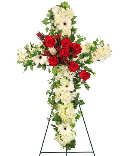 Peaceful Crossover In Red - Praise your loved one with a floral cross that will truly represent their devotion to their friends, family, and community. The Peaceful Crossover standing spray brings beauty and reassurance to any funeral service, memorial service, or wake. Featuring gentle Gerbera daisies and roses in stunning whites, elegant pale green hydrangeas, and radiant red roses, this floral cross brings peace and comfort to those who are mourning.