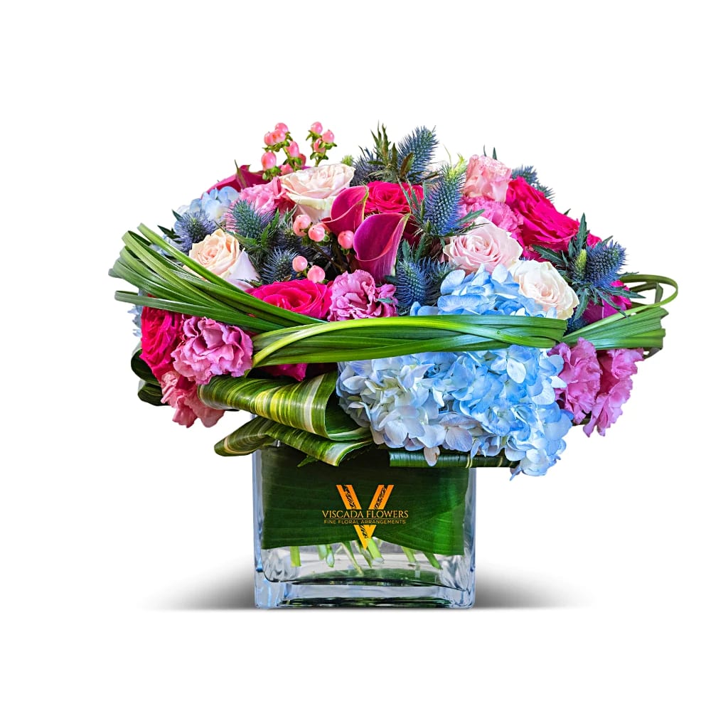 Iced Berries - Cool and enchanting, this bouquet features a delightful blend of hot pink roses, white roses, pink calla lilies, blue hydrangeas, and blue sea holly. Perfect for adding a refreshing and vibrant touch to any space.