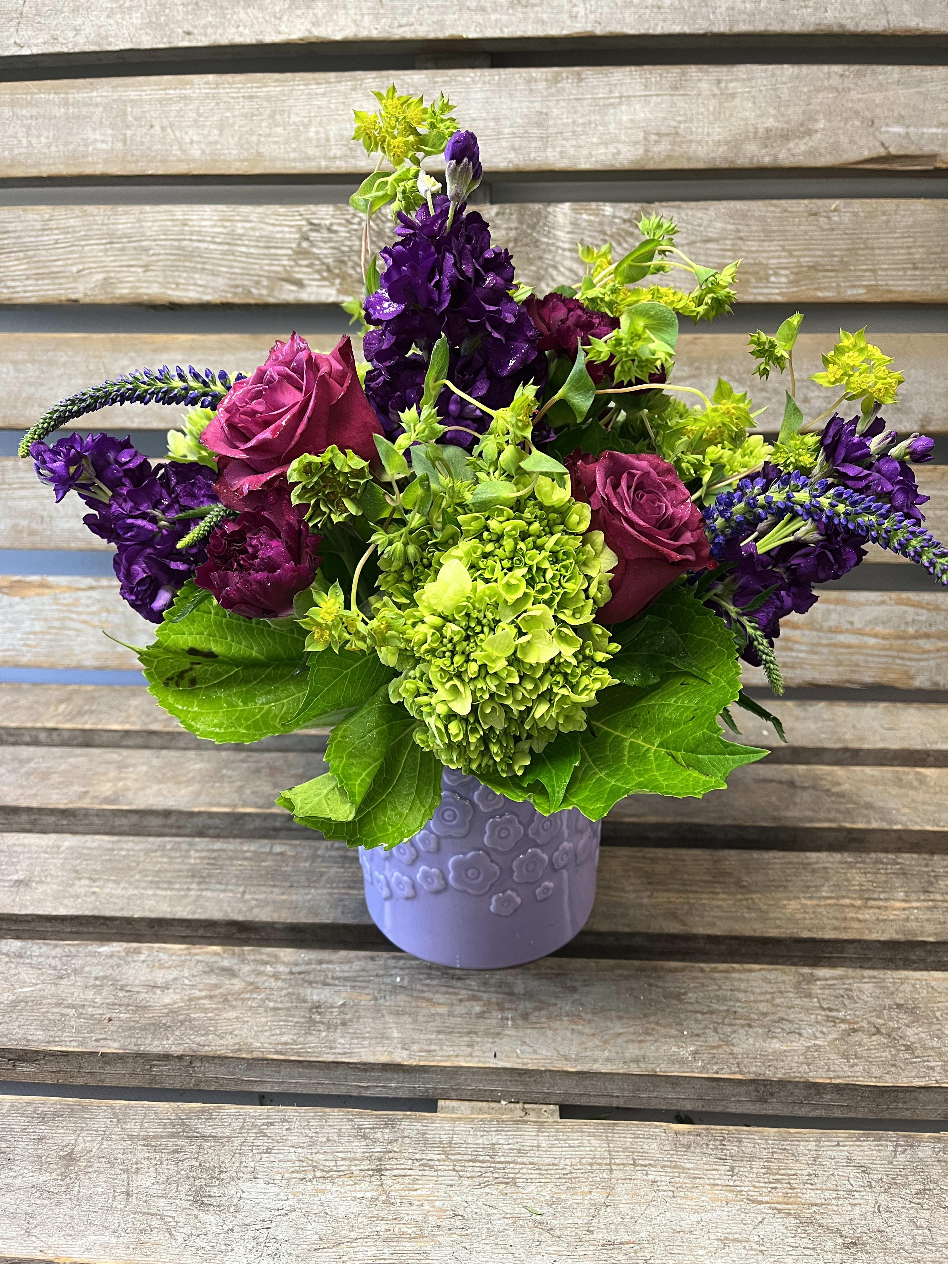 Spring special lavender posy vase  - An adorable lilac colored vase filled with shades of green and purple flowers. We will use freshest flowers available that week to include hydrangea, roses , stock ,carnations etc… 