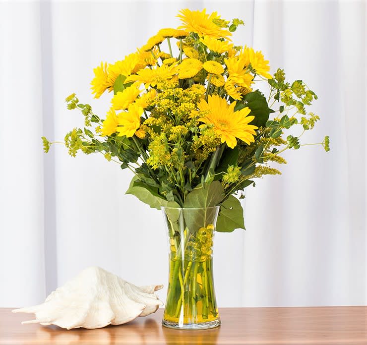 Mellow Yellow - Sunshine and meadows in a vase! Cheerful Daises and Mums with Aster arranged as a fun bouquet in a glass vase.