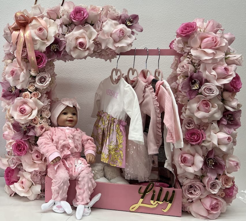 Welcome baby girl  - We are excited to introduce our latest addition, a stunning floral arrangement shaped as a closet. This beautiful piece will add a touch of elegance and sophistication to any room. Please note that we do not provide the clothing, shoes, baby doll, name decal, racks, or chocolate shown in the product images. Our focus is solely on providing our customers with the highest quality floral arrangements. We take pride in our attention to detail and commitment to excellence. Order yours today and experience the beauty of our floral artistry!