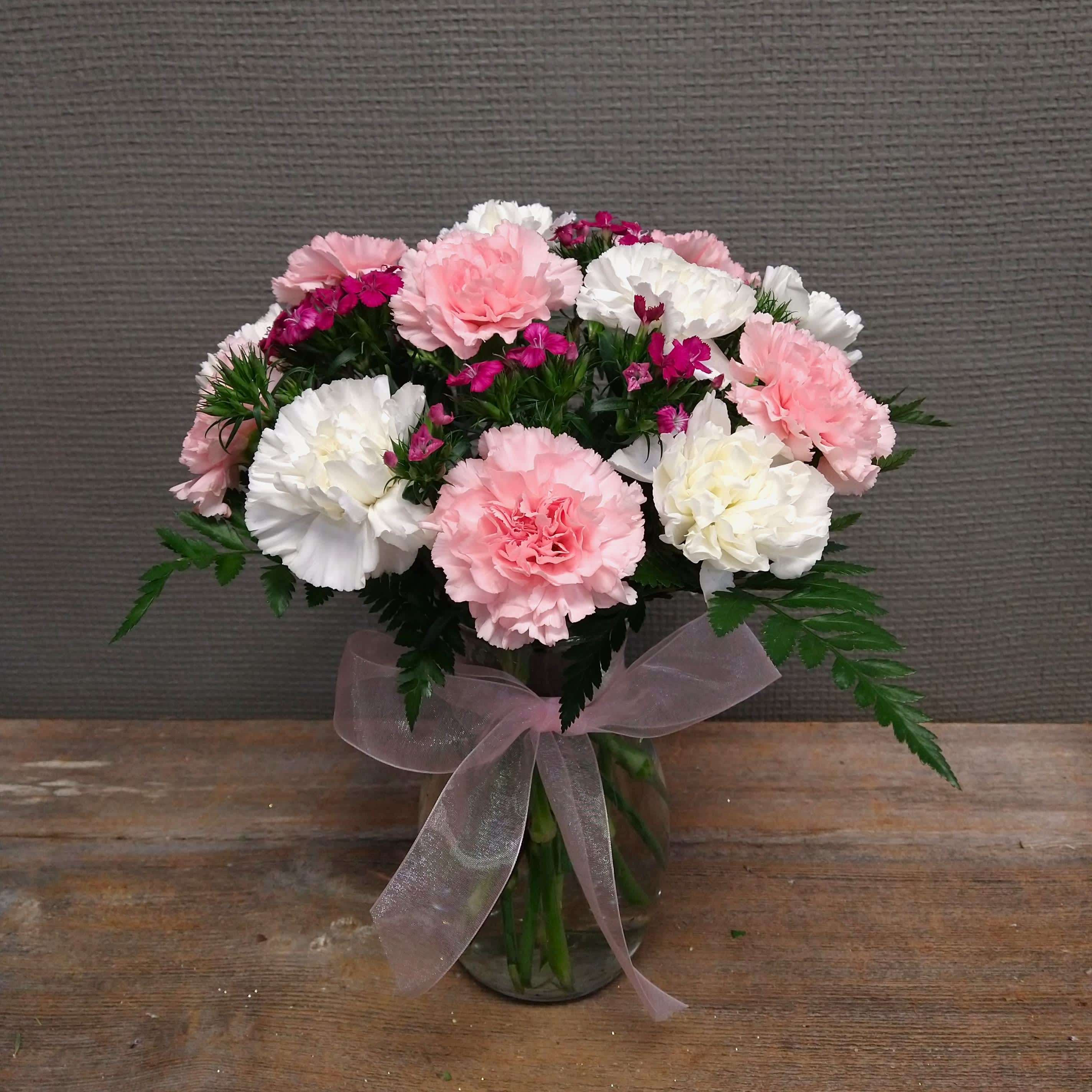 Carn-ival of Love - Remind your sweetheart of cotton candy and carousels with this super sweet arrangement. A dozen long-lasting pink and white carnations with bright gypsy dianthus filler. Perfect size for a desk, kitchen counter, or other small space! Upgraded sizes have 18 and 24 carnations respectively.