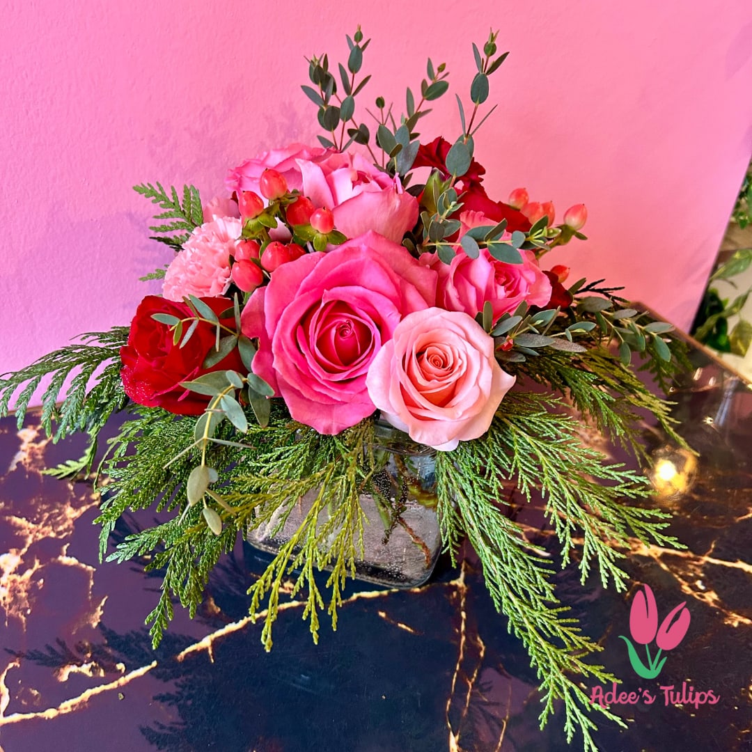 Rosy Rendezvous - A beautiful vase arrangement of pink and red blooms, paired with eucalyptus and evergreens. 