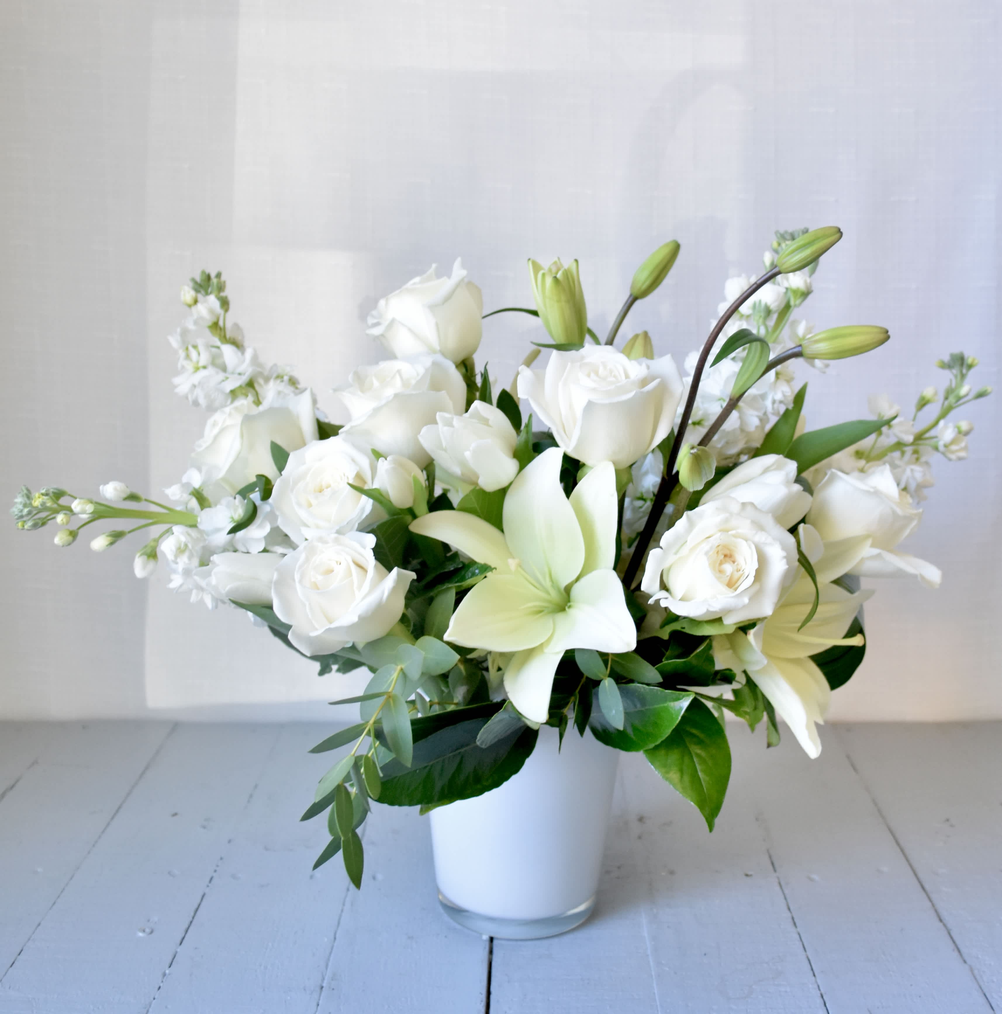 Gracefully Elegant - Gracefully Elegant is a modern and compact white arrangement filled with luxury flowers such as Lilies and imported Roses as well as seasonally available flowers sourced from our local growers. It's the perfect gift when you want to make a statement. 
