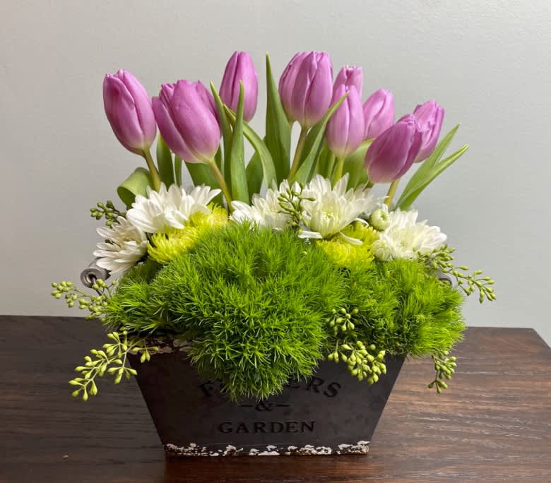 Tulip Garden Tulip Garden - A perfect design to welcome spring and new beginnings. This design is sure to brighten the receiver's day! Including Pink Tulips, Green Trick, and mixed Daisies.