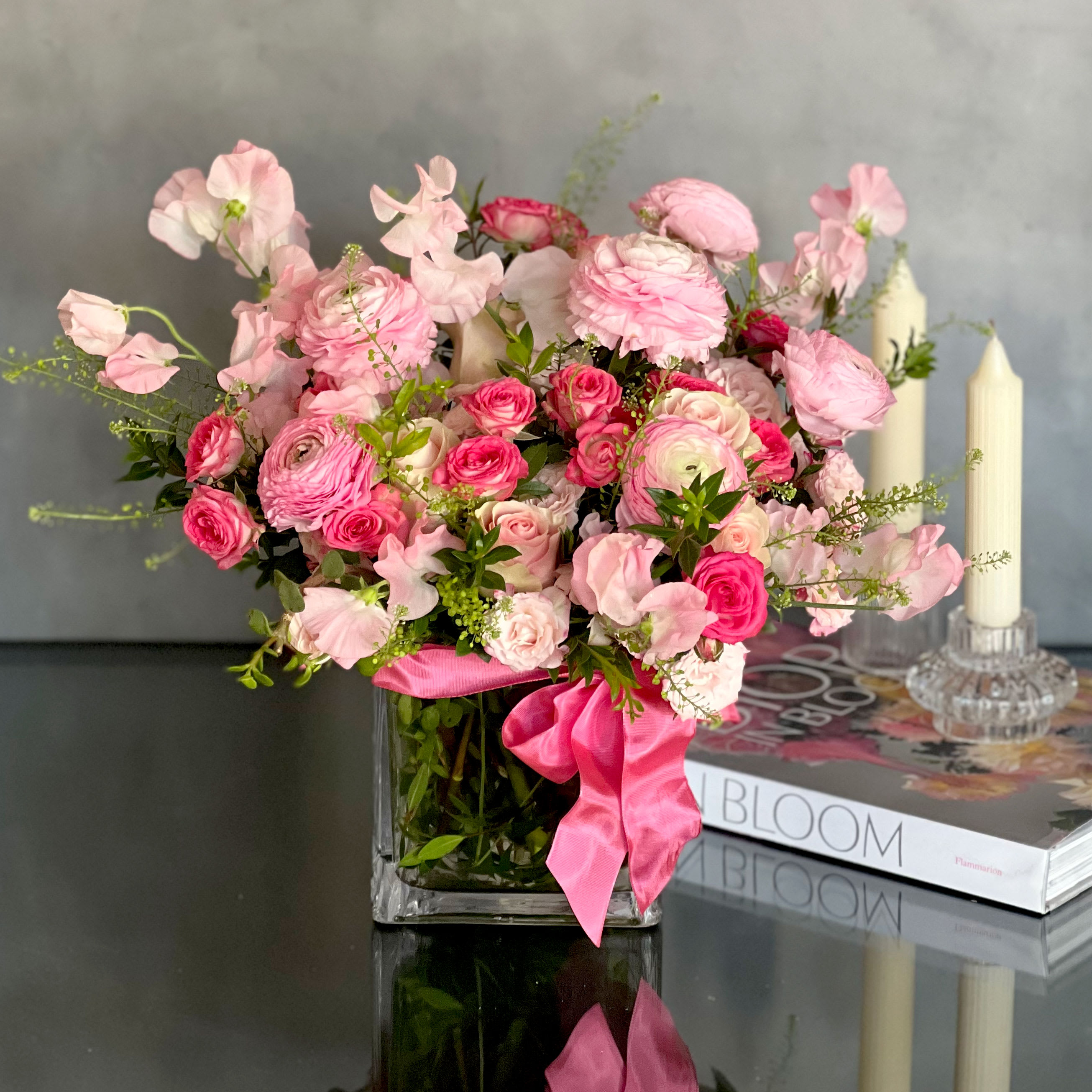 Pretty in Pink - A gorgeous collection of Imported Sweet peas , Dutch Ranunculus and Roses nested in a clear 6x6 square glass vase. This bouquet is a perfect gift for someone that draws in the attention of a room.  overall: 16&quot; x 18&quot; inches