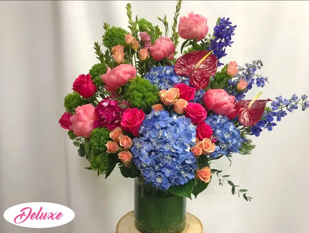 Live Lively Arrangement  - Absolutely Magnificent!!! What a cheerful flower arrangement, sure to brighten anyone's day!! A glass vase is packed full of hydrangea, roses, larkspur, anthurium and other seasonal flowers.