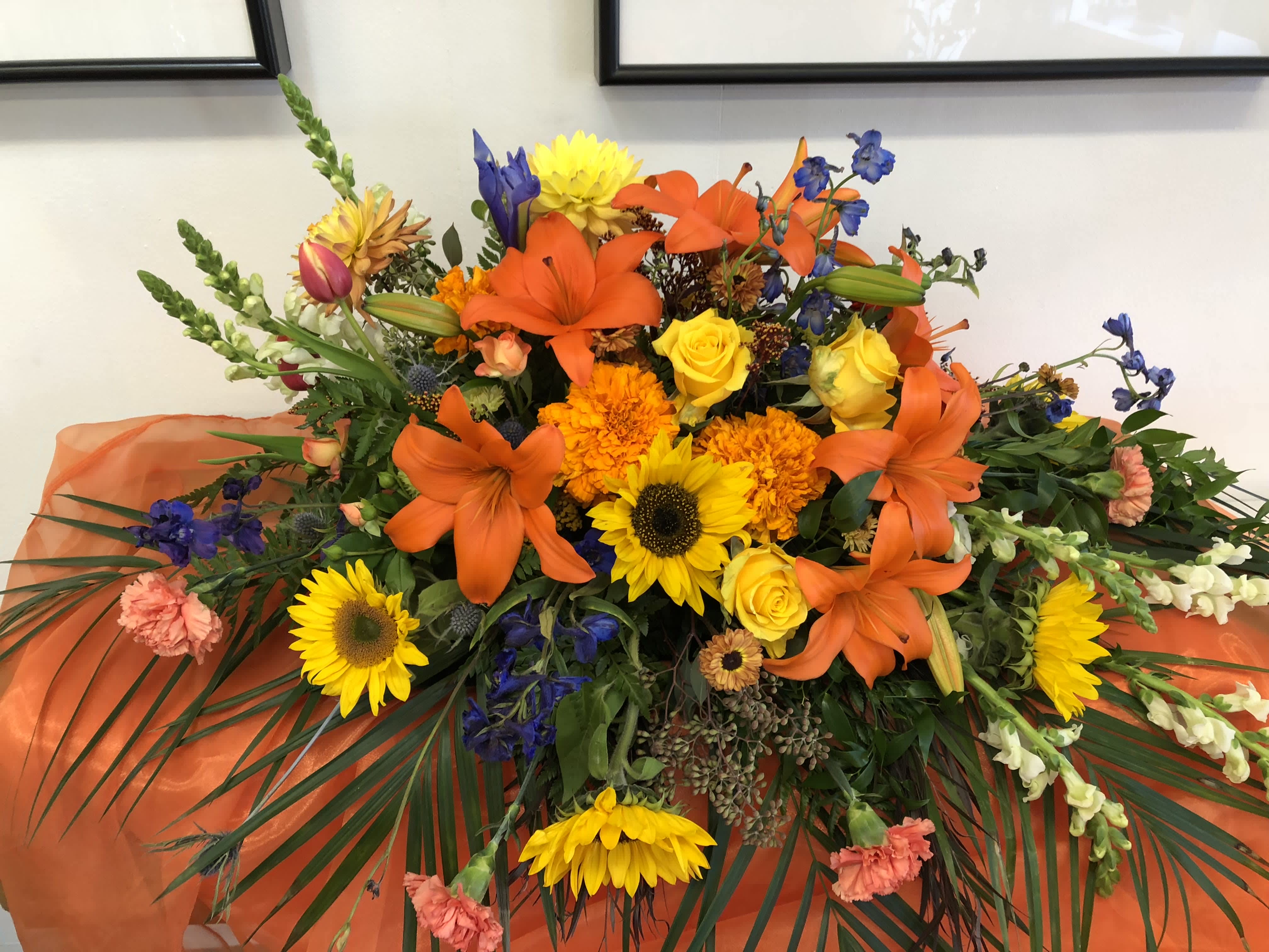 Fall Tone Casket Spray - Casket Spray With roses and sunflowers  Brighten any room with these fall tone Roses, Gladious and, Lilies. 